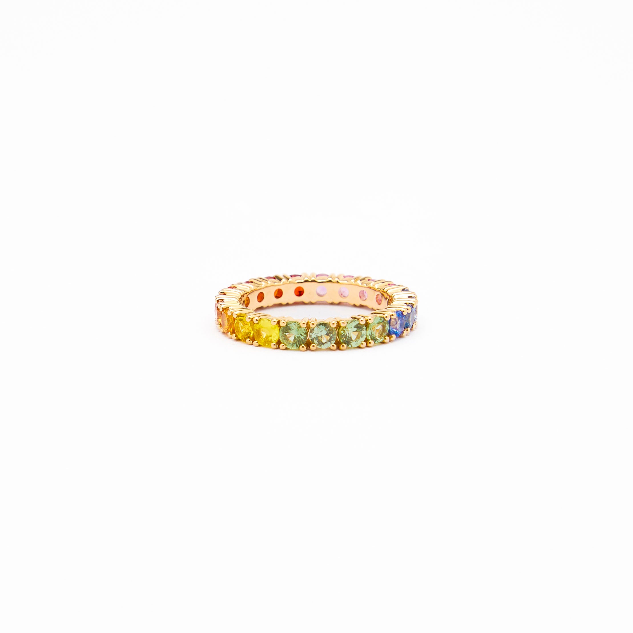 Beautiful eternity rainbow sapphires ring on white background.
