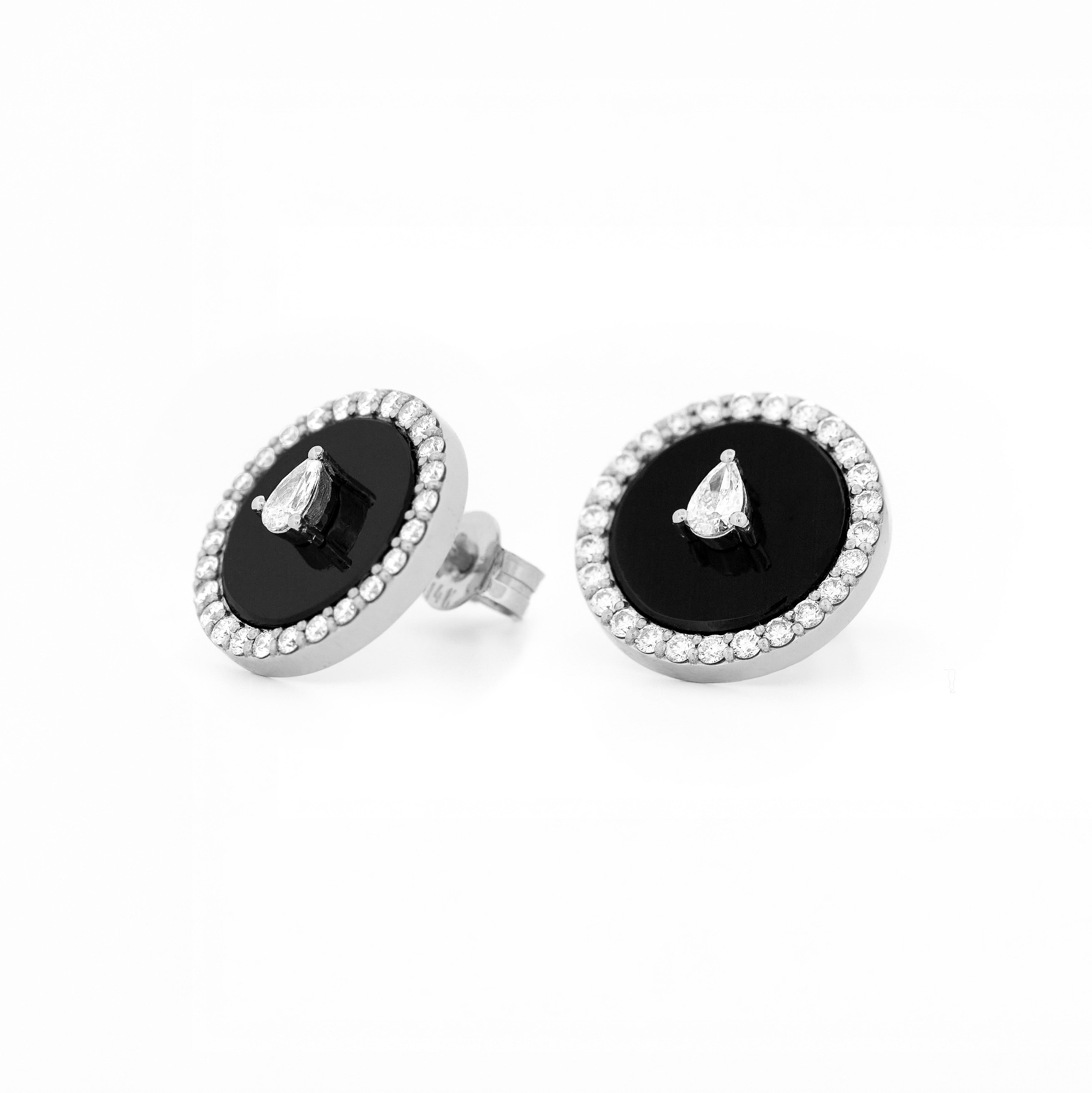 Pair of earrings with black onyx center stone and teardrop and round shape diamonds accents on a white background
