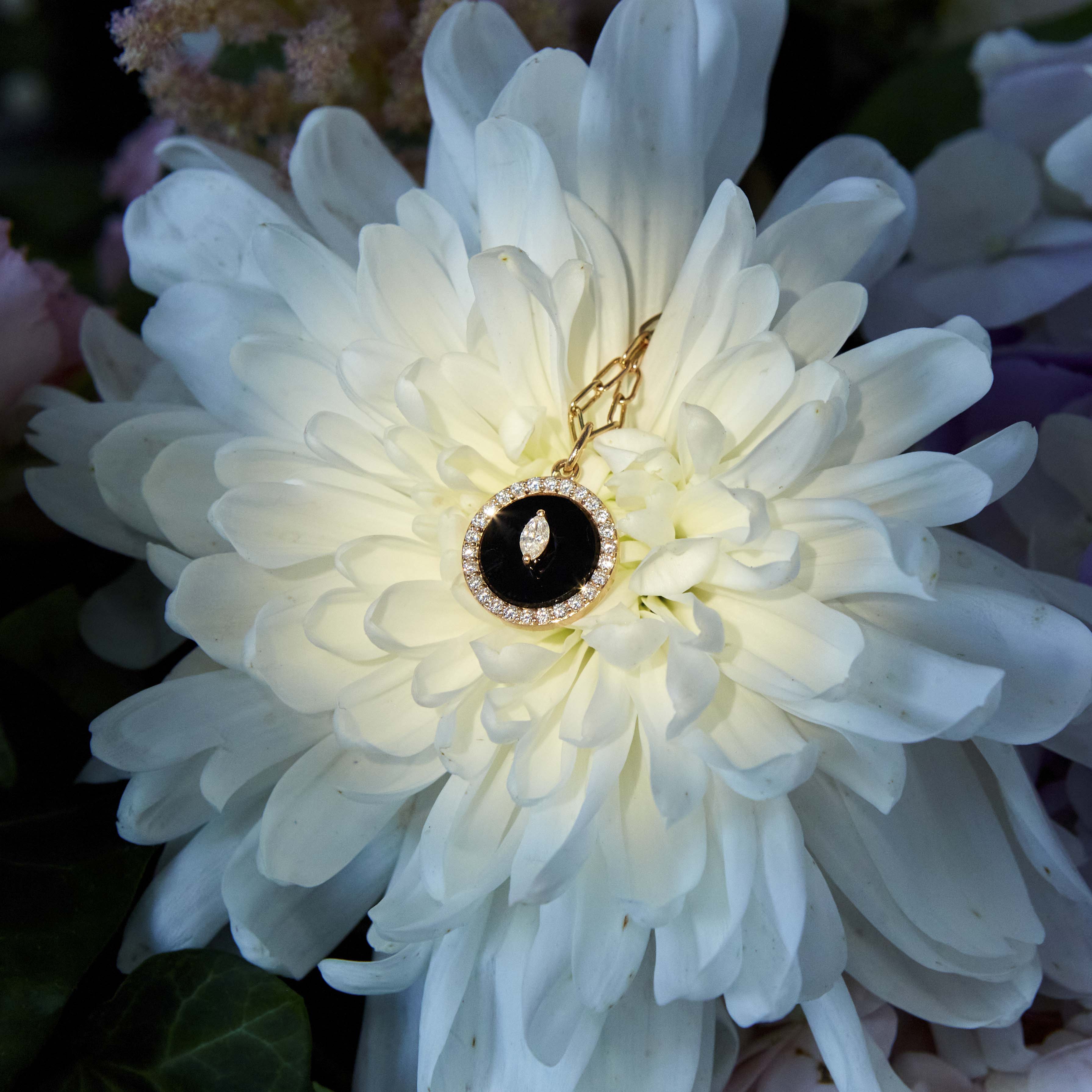 Black Onyx and White diamonds protection pendant on a flower. Pandant Protection cu Onix negru si diamante asezat pe o floare, dahlia.