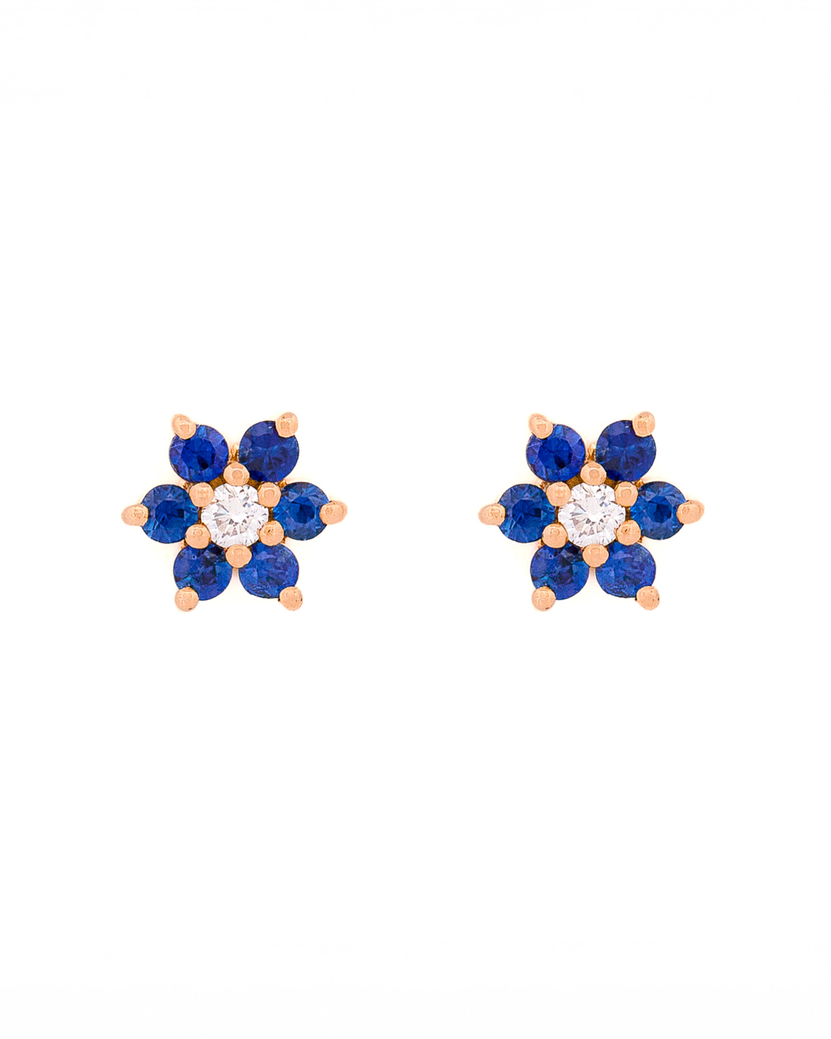 Pair of floral earrings with blue sapphires and diamonds and gold accents on a white background