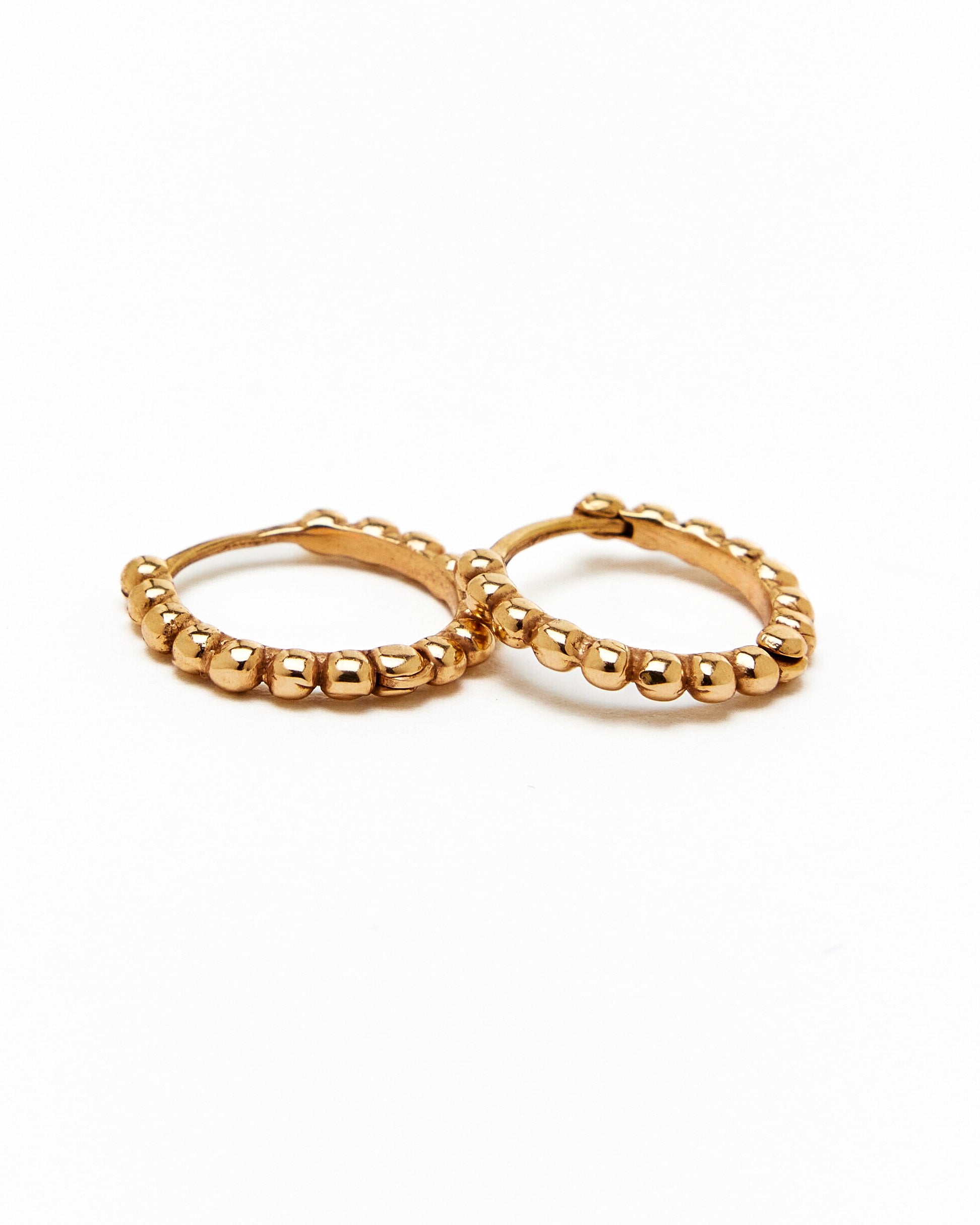 A pair of gold hoop earrings with a beaded design, made to order.