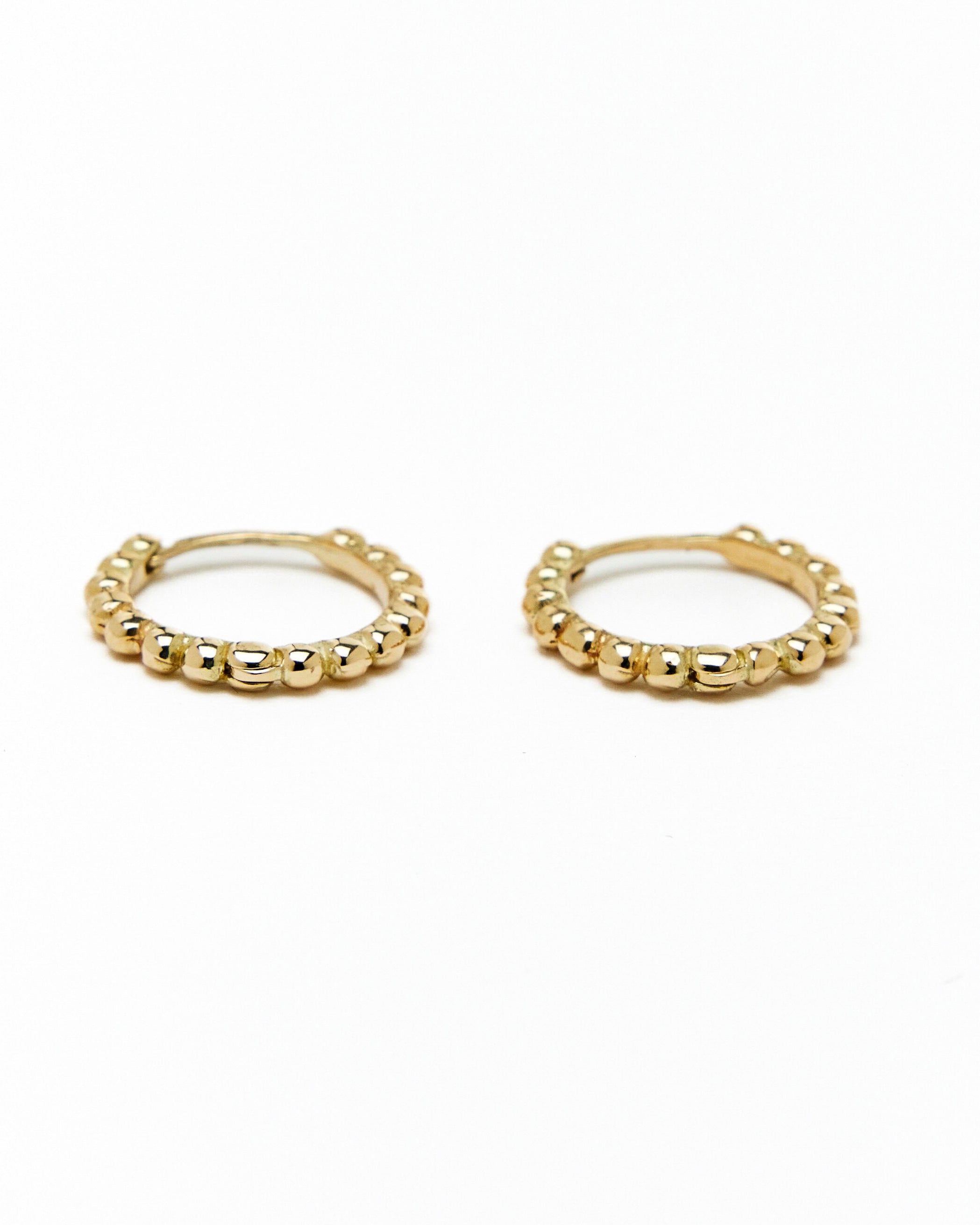 A pair of gold hoop earrings with a beaded design, made to order.