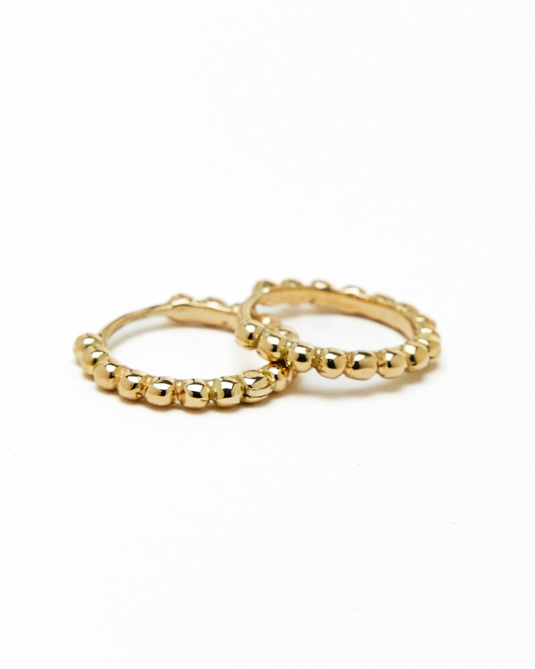 A pair of gold hoop earrings with a beaded design, made to order.