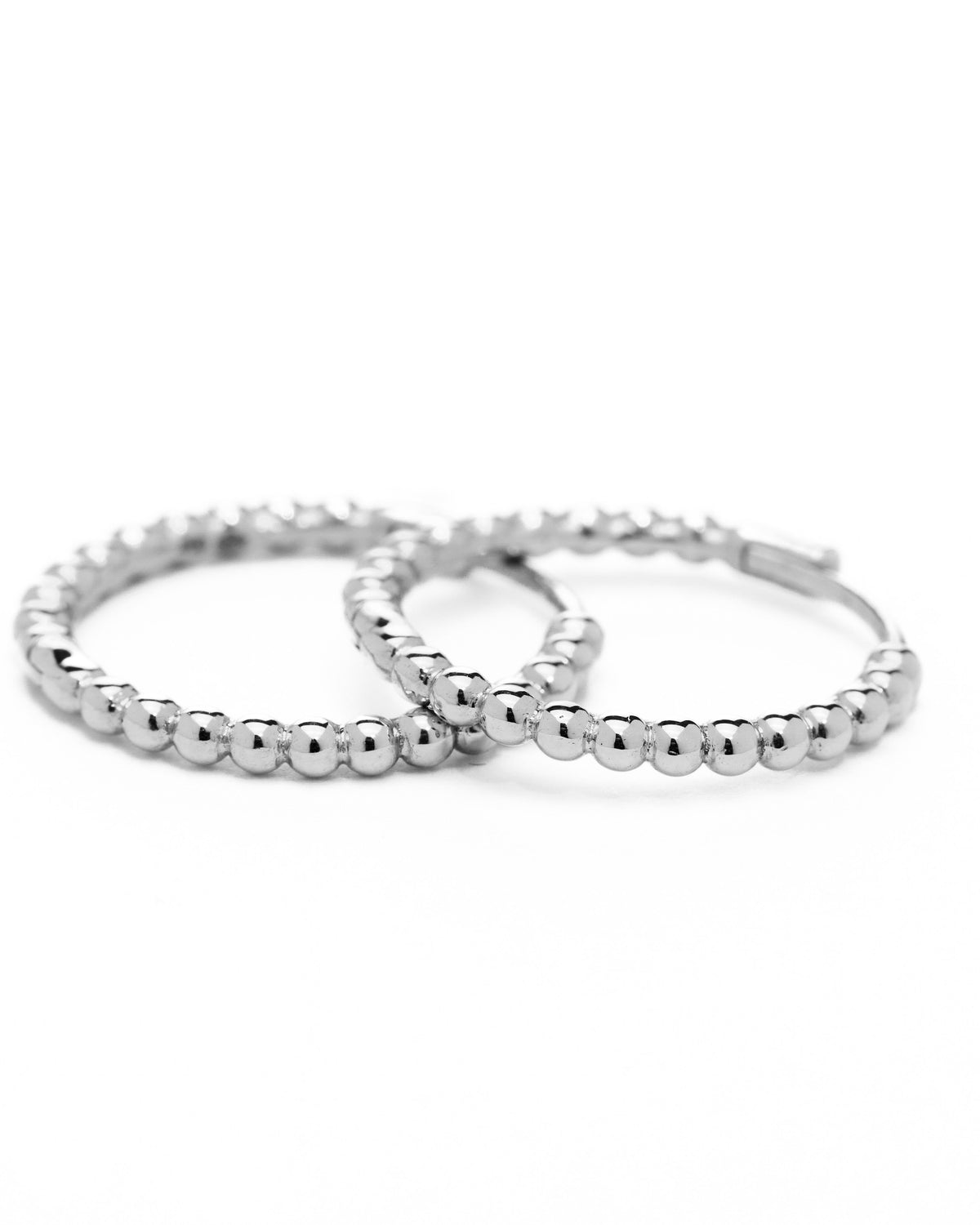 A pair of white gold hoop earrings with a bubbly design, displayed against a white background.