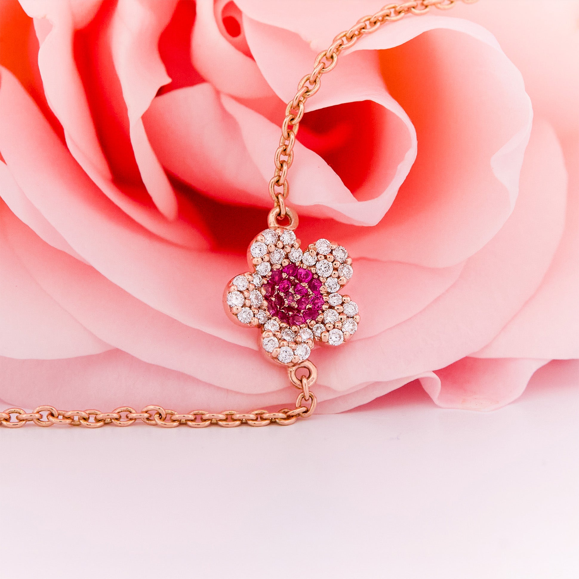 Rose gold bracelet with a ruby and diamonds flower on a rose flower