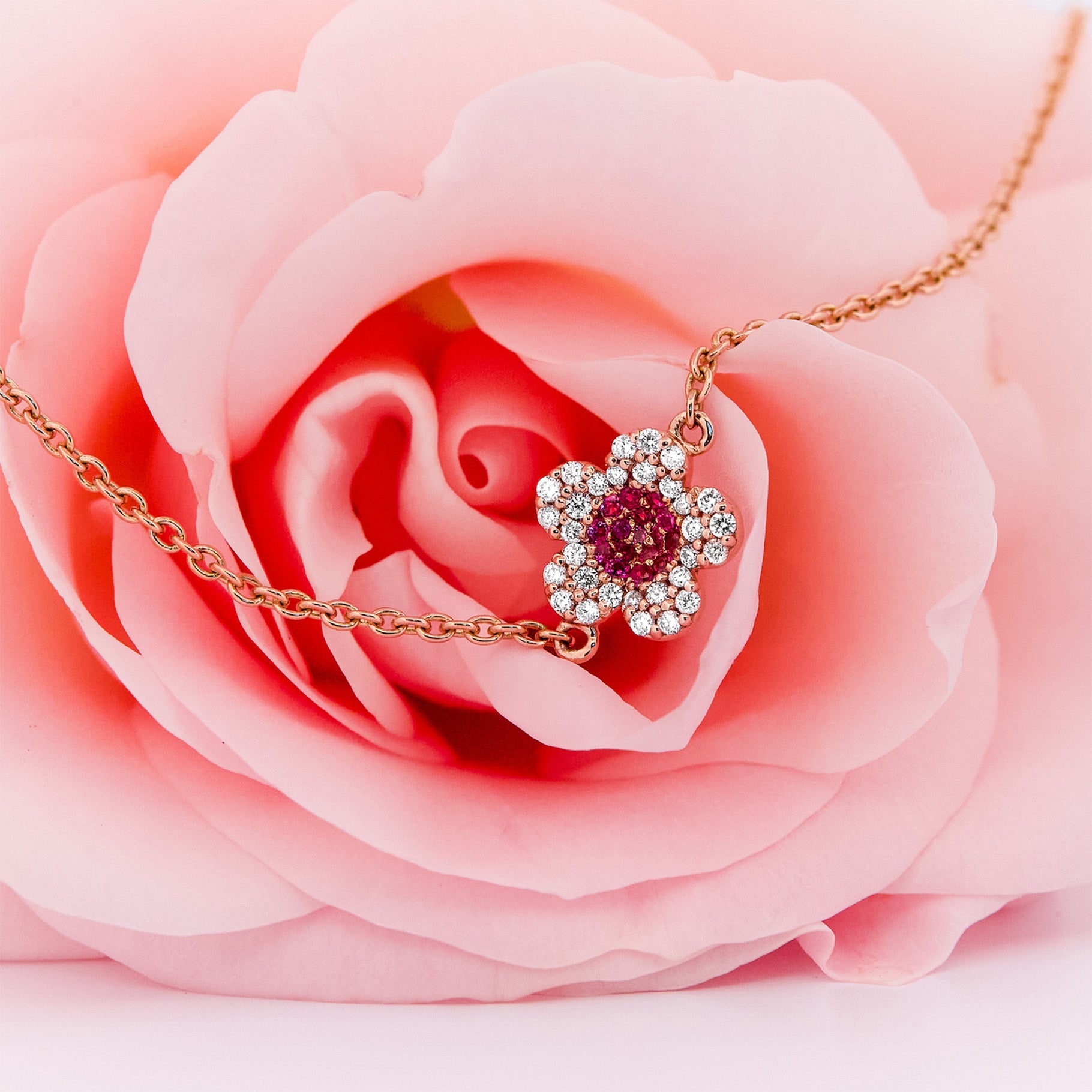 Rose gold bracelet with a ruby and diamonds flower on a rose flower