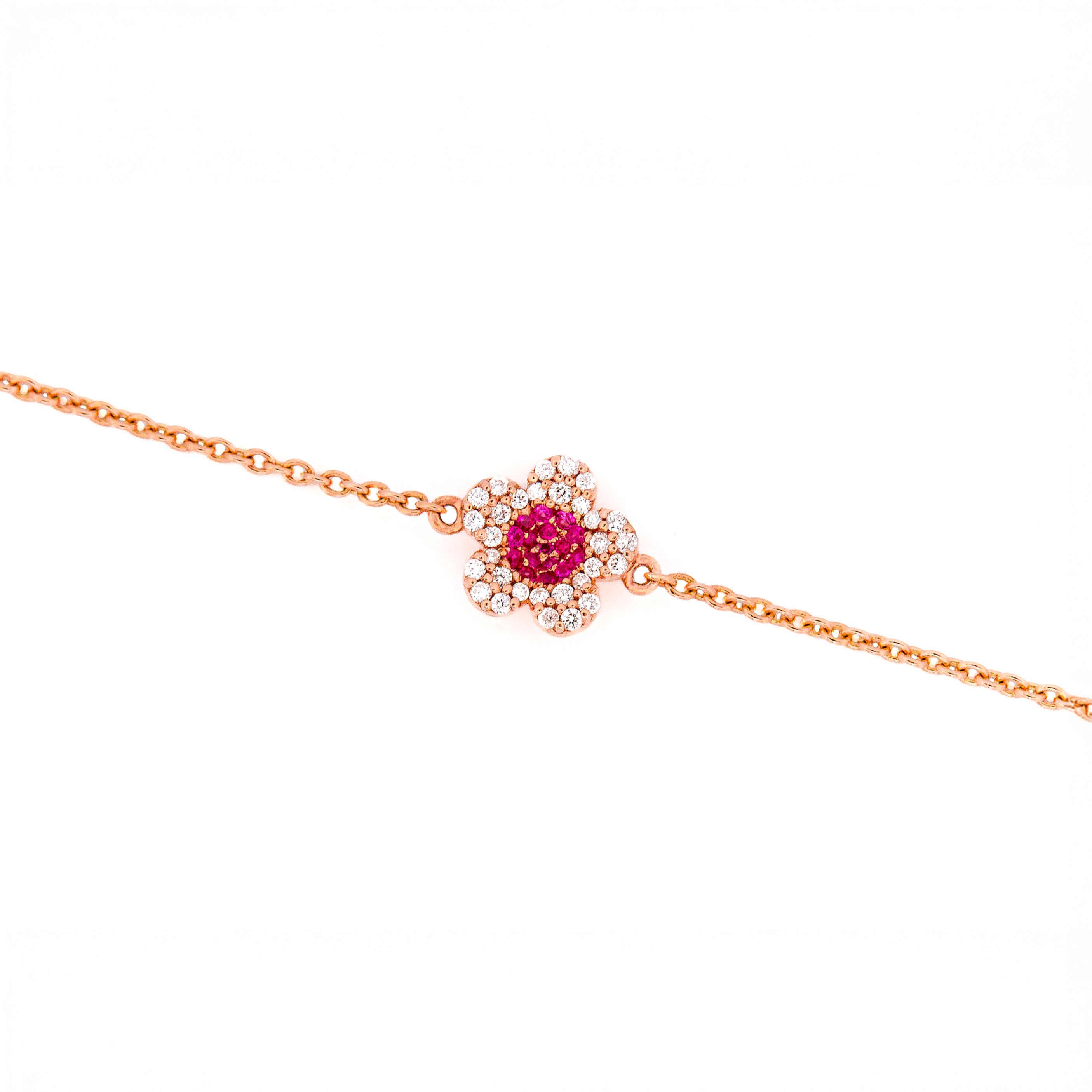 Rose gold bracelet with a ruby and diamonds flower on a white background