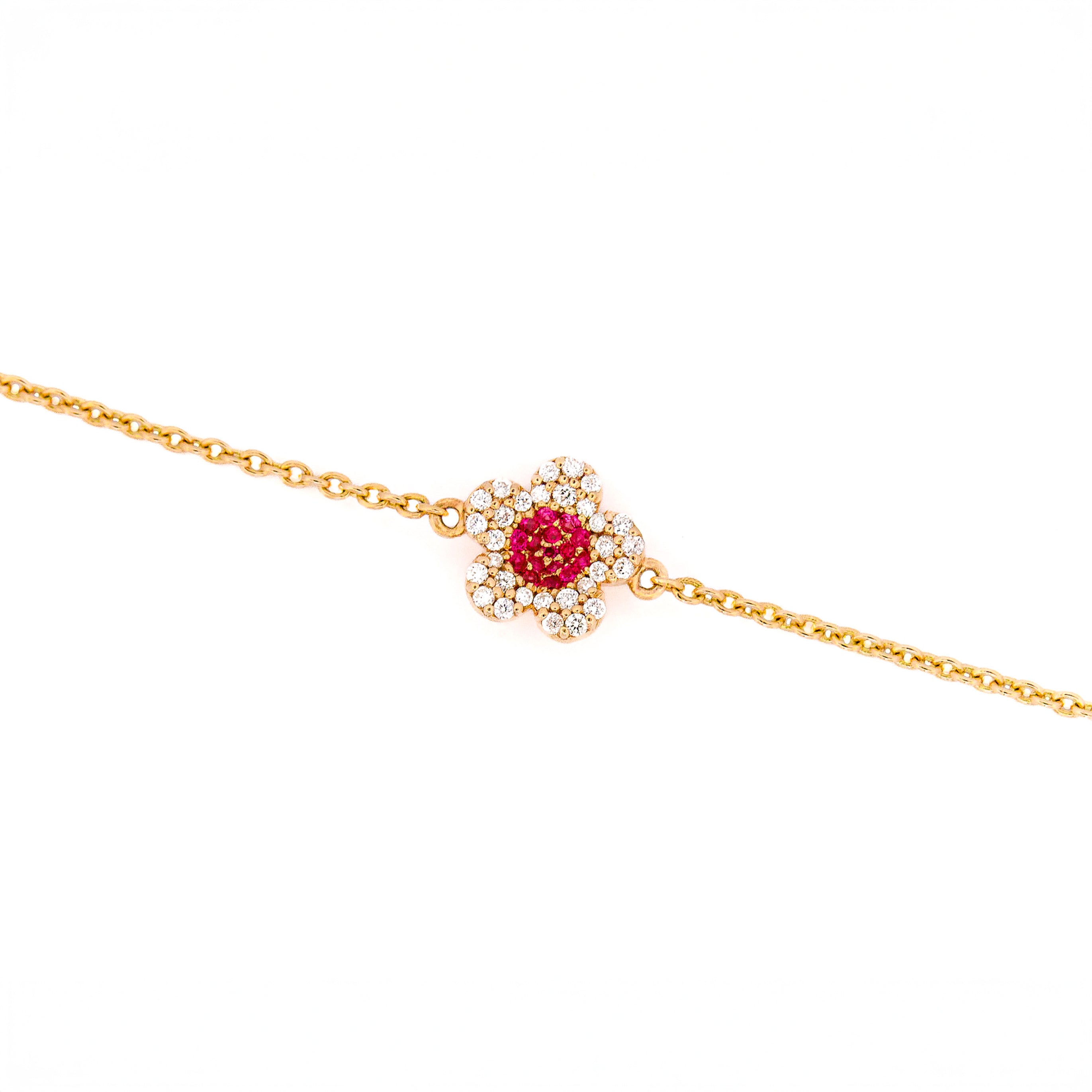 Yellow gold bracelet with a ruby and diamonds flower on a white background