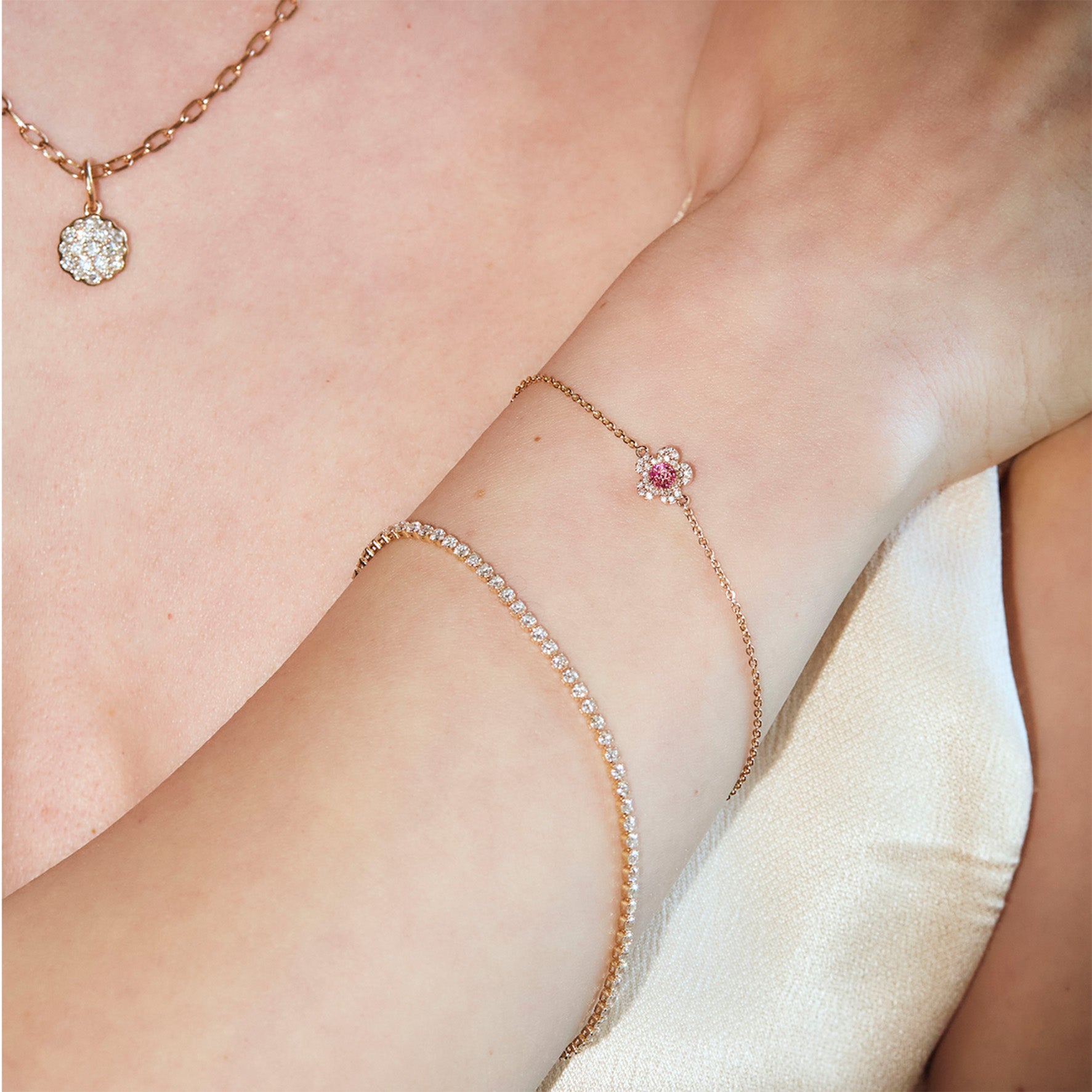 Rose gold jewelry set including a necklace, diamonds tennis bracelet, and a cherry blossom diamonds flower bracelet on a person's arm.