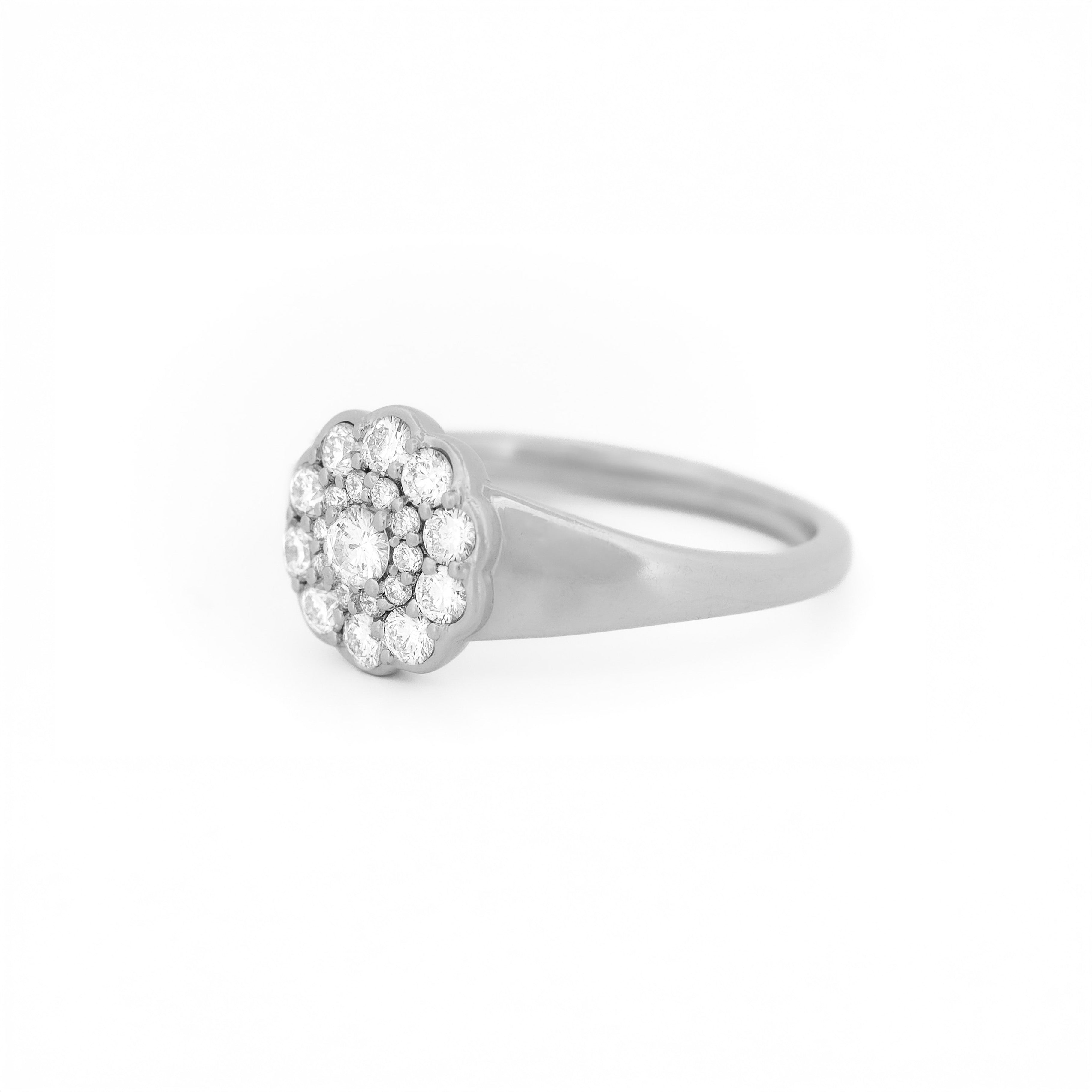 White gold ring with diamond cluster daisy flower on a white background