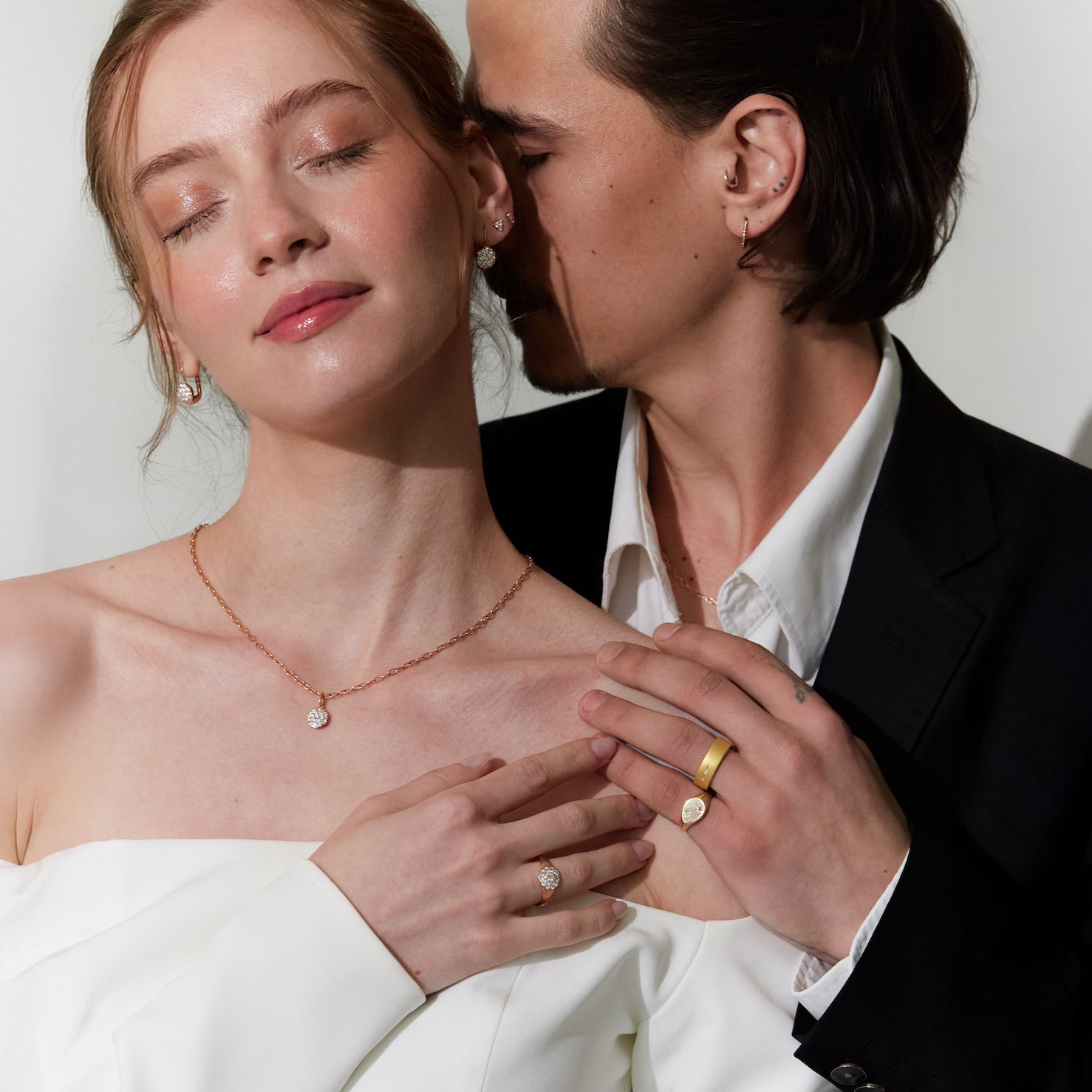 Couple wearing wedding jewelry, with a focus on the daisy diamonds necklaces and diamonds rings.