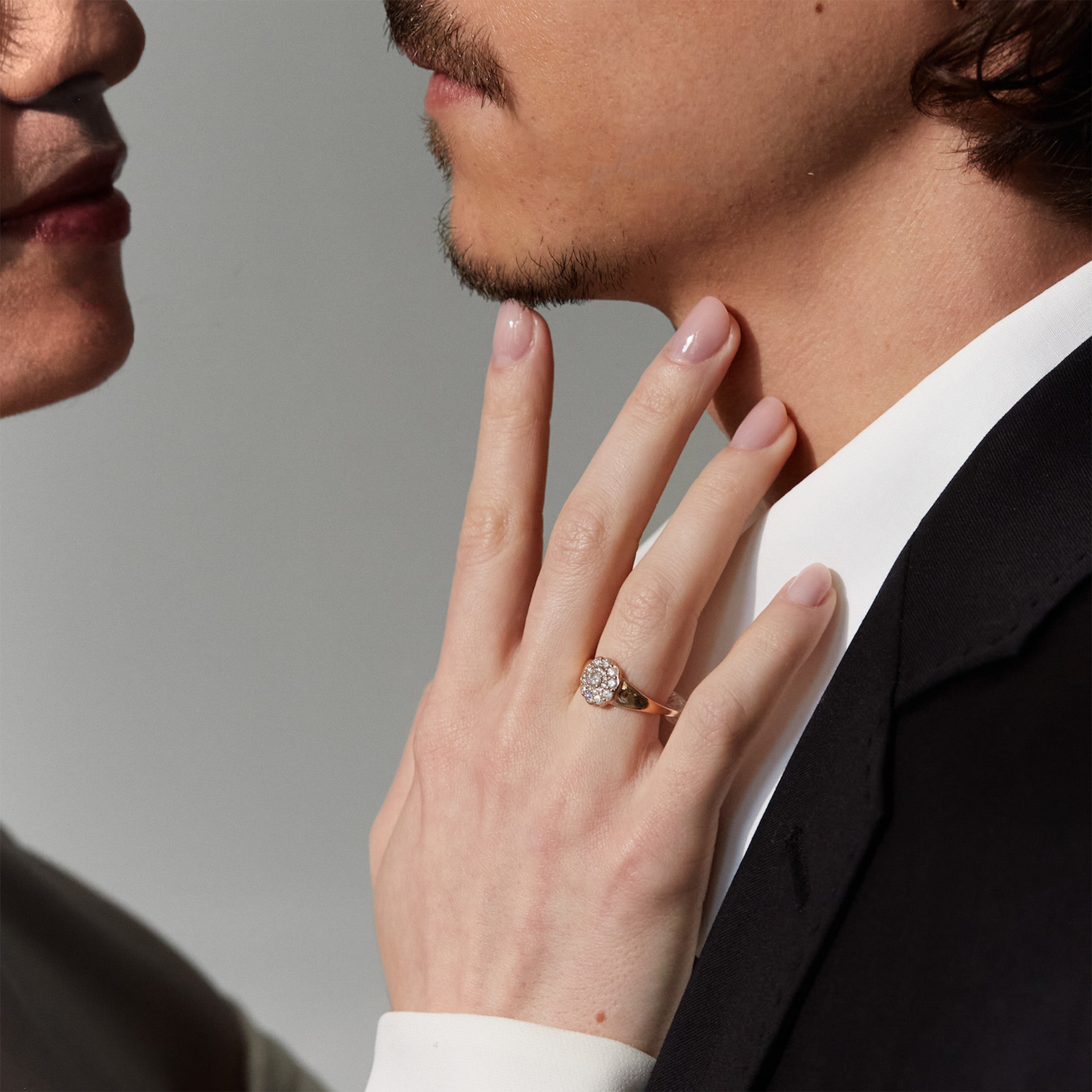 Close-up of a hand with a diamond flower ring on a blurred background