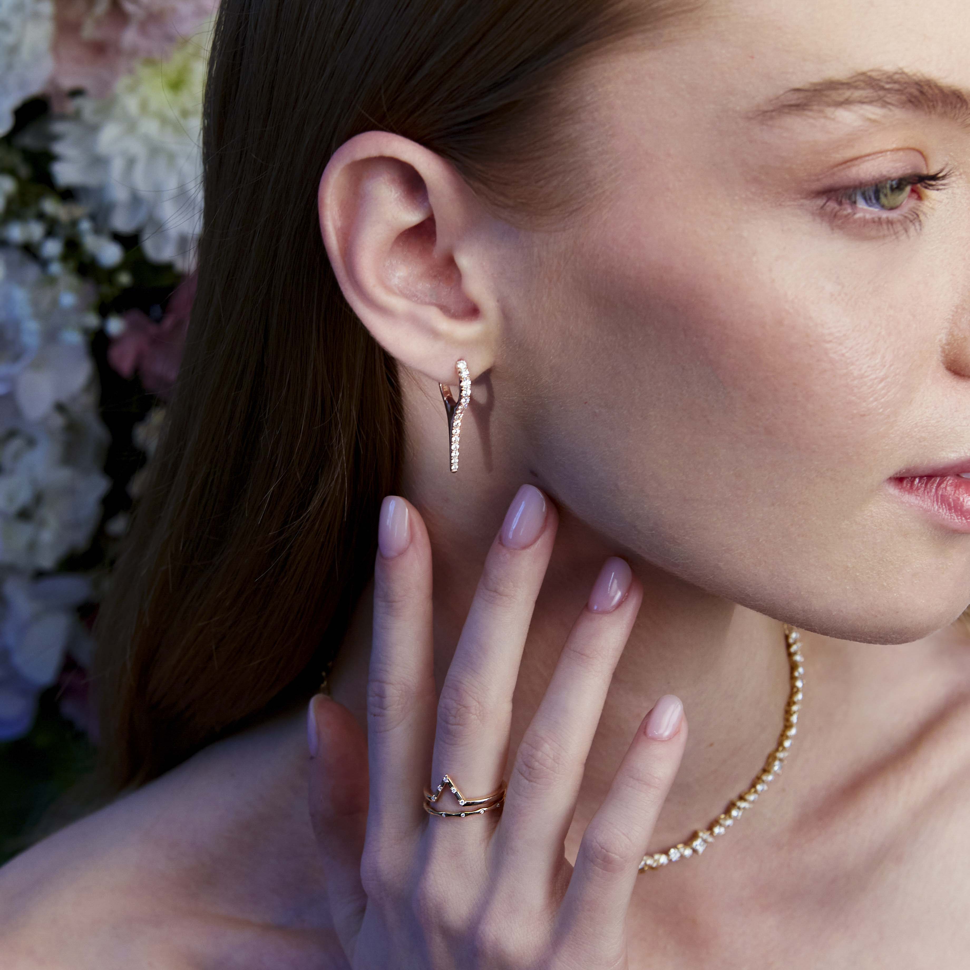 A beautiful diamond earring in the shape of an icicle on the ear.
Un cercel cu diamante spectaculos în formă de țurțure văzut pe ureche.