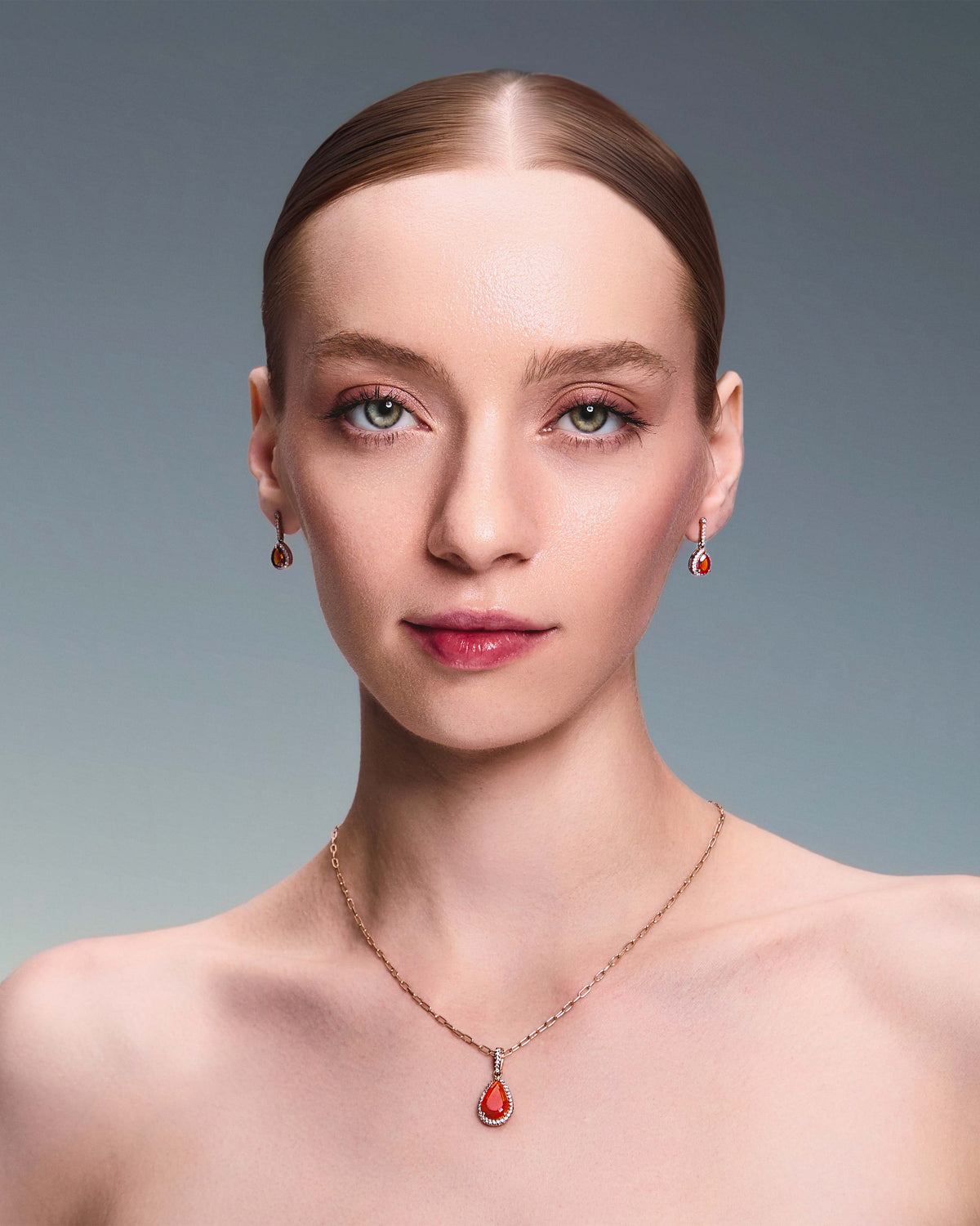 teardrop earring in red gold with diamonds and a teardrop fiery citrine. The beautiful model in also wearing a matching pendant.