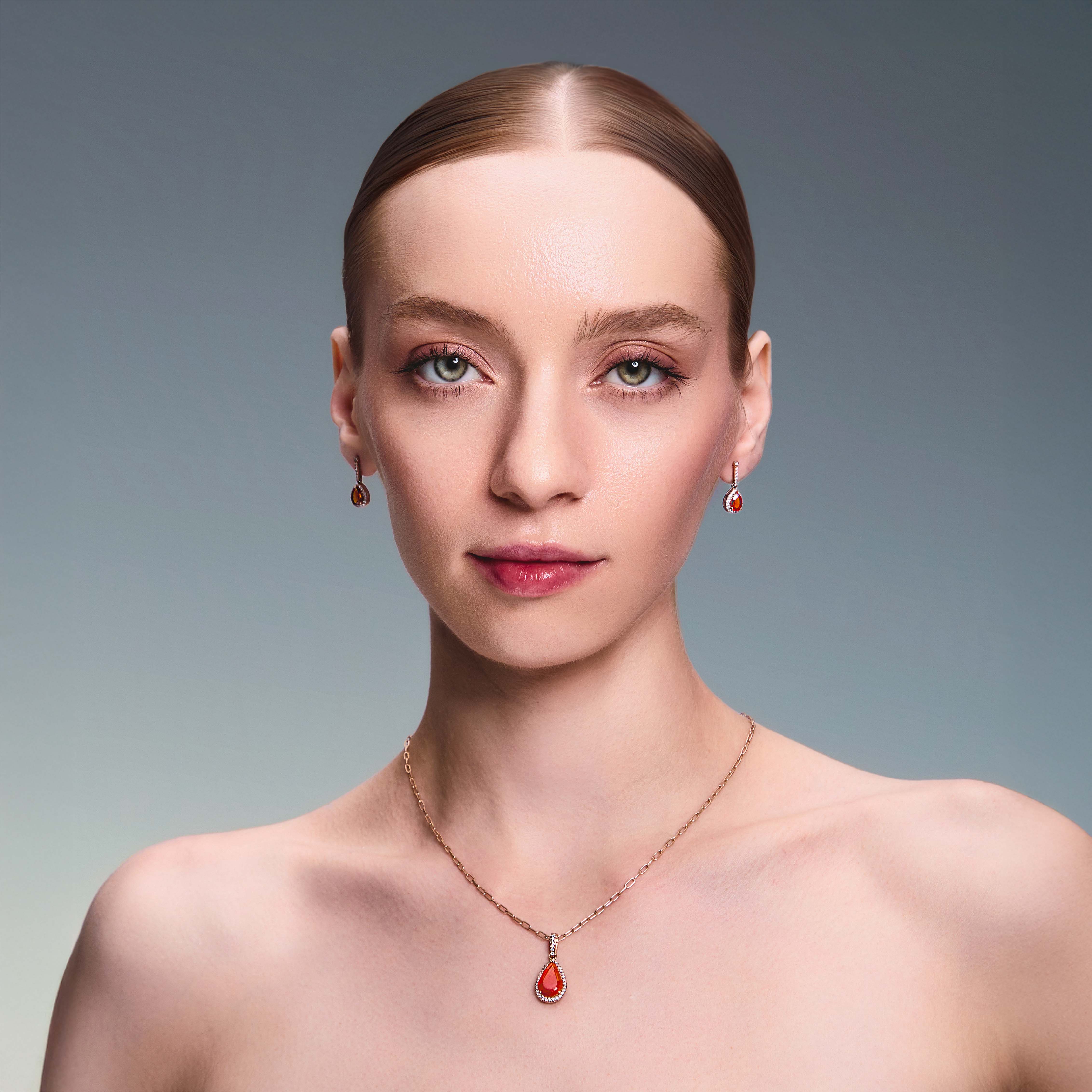 teardrop earring in red gold with diamonds and a teardrop fiery citrine. The beautiful model in also wearing a matching pendant.