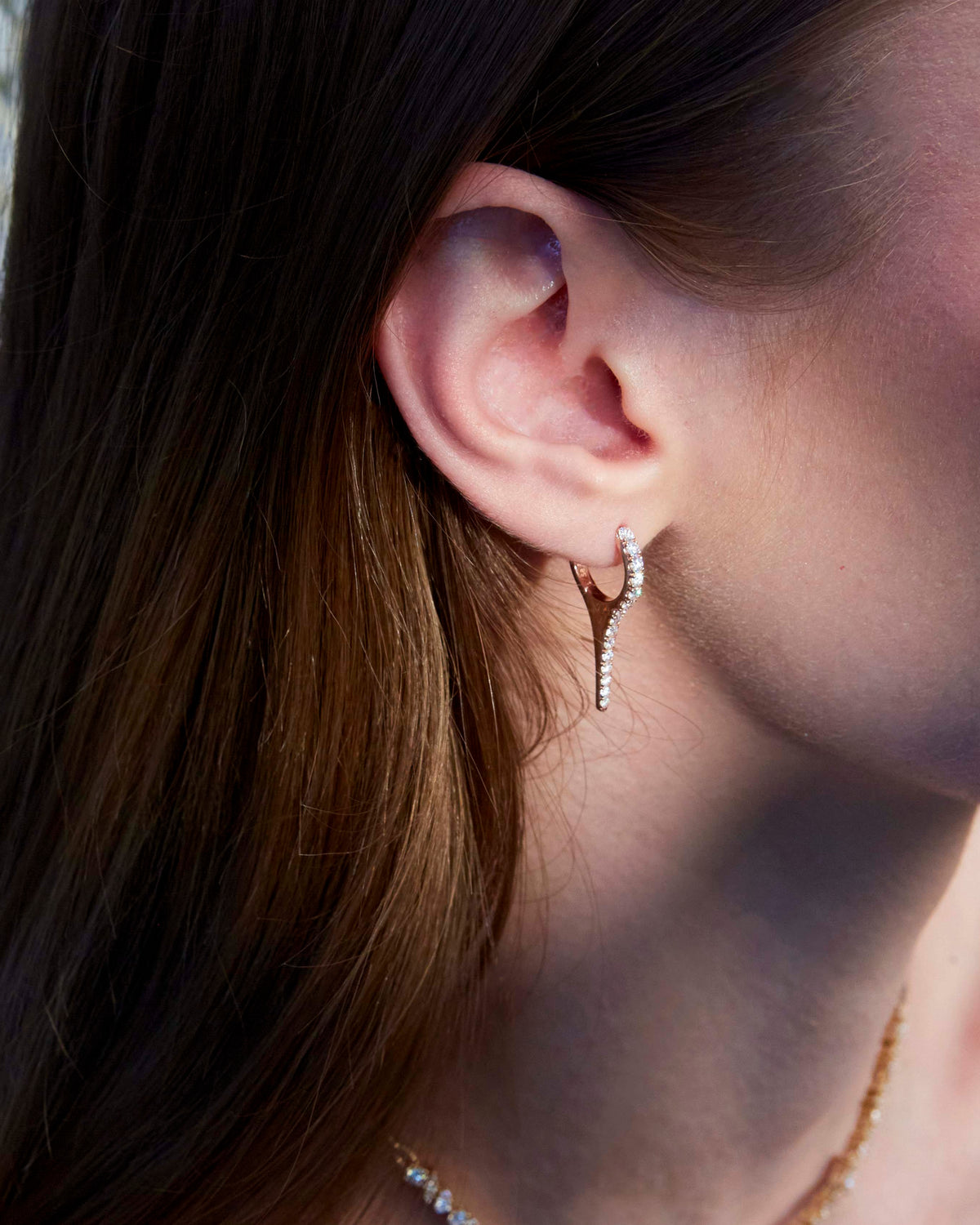 A beautiful diamond earring in the shape of an icicle on the ear.
Un cercel cu diamante spectaculos în formă de țurțure văzut pe ureche.