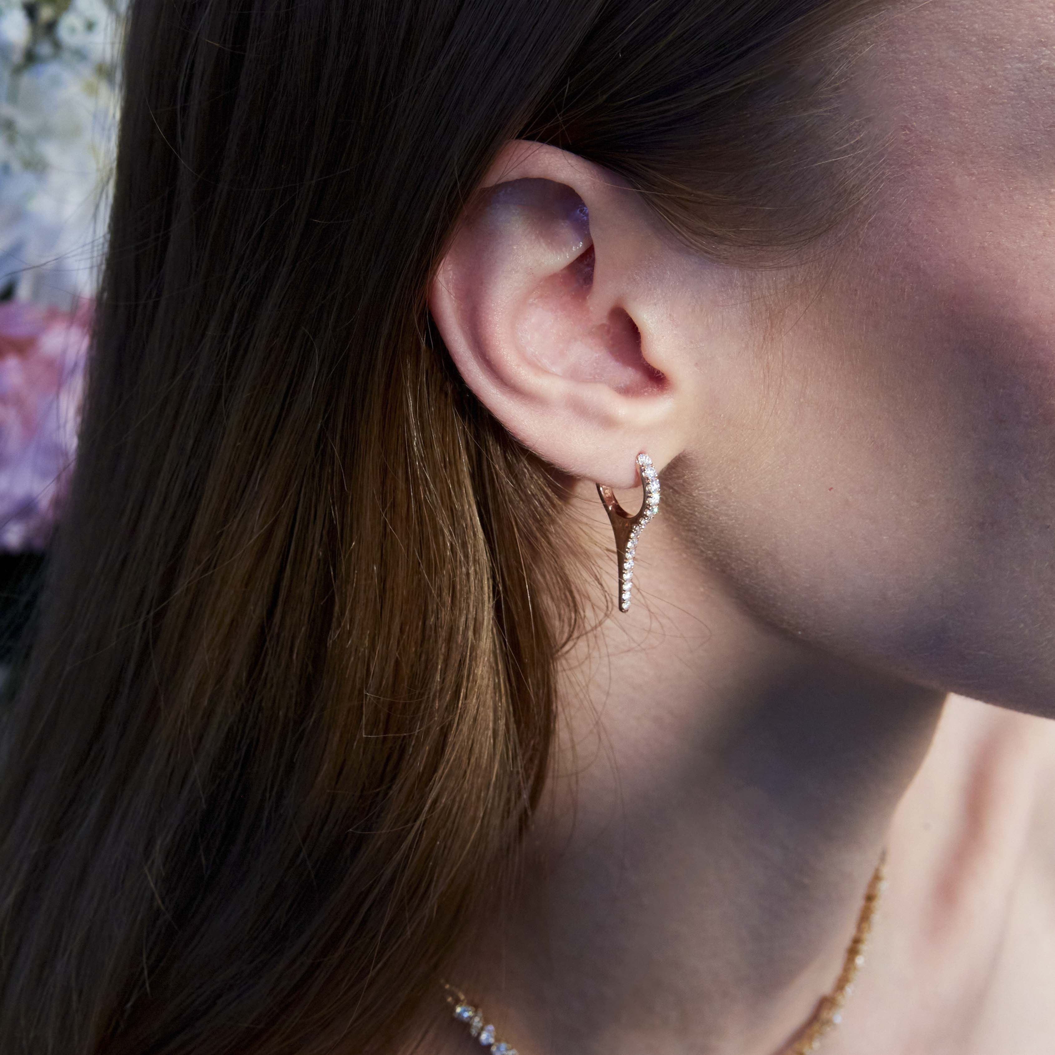 A beautiful diamond earring in the shape of an icicle on the ear.
Un cercel cu diamante spectaculos în formă de țurțure văzut pe ureche.