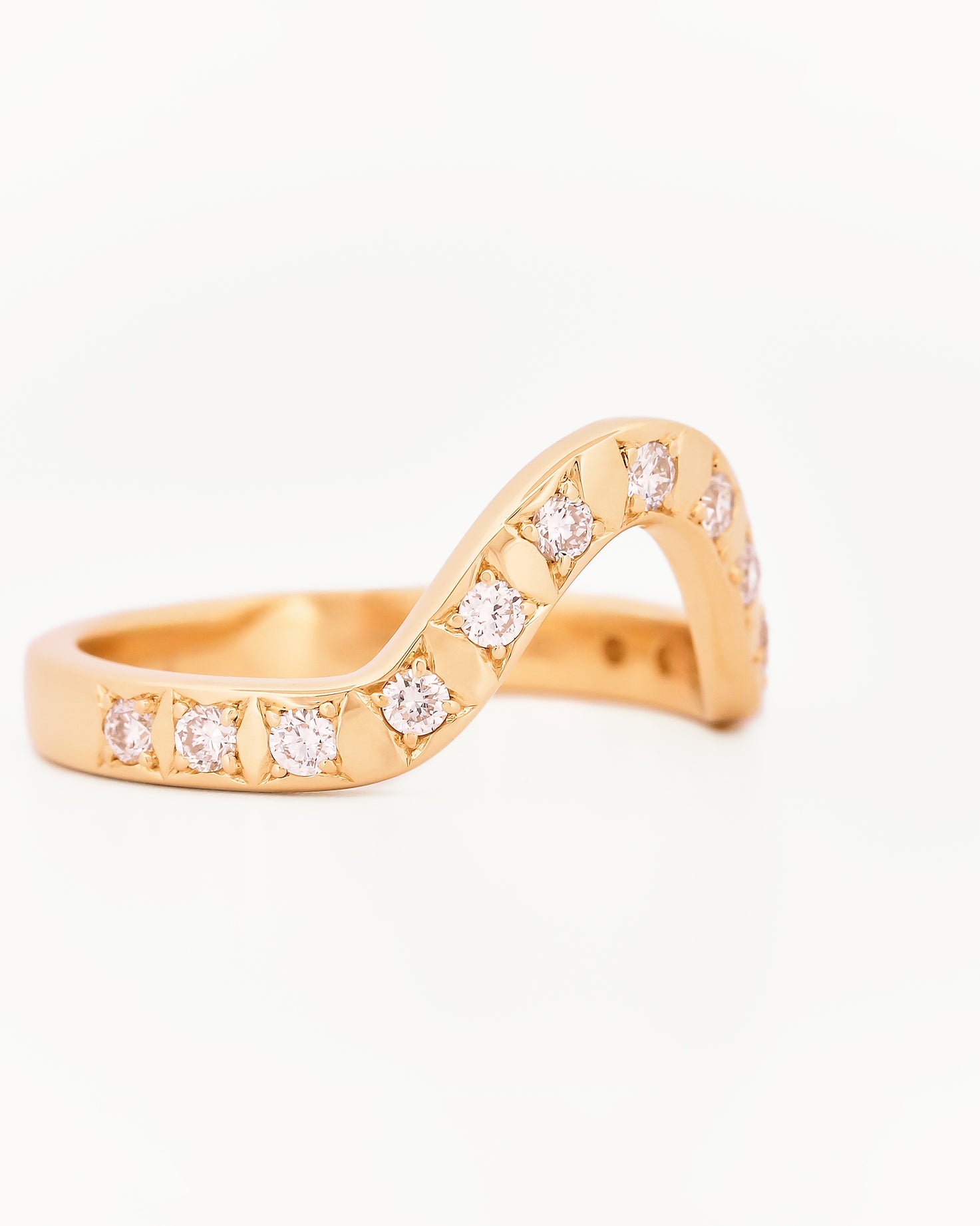 Yellow gold 2.5 mm band ring with 13 round diamonds diamonds on a white background.