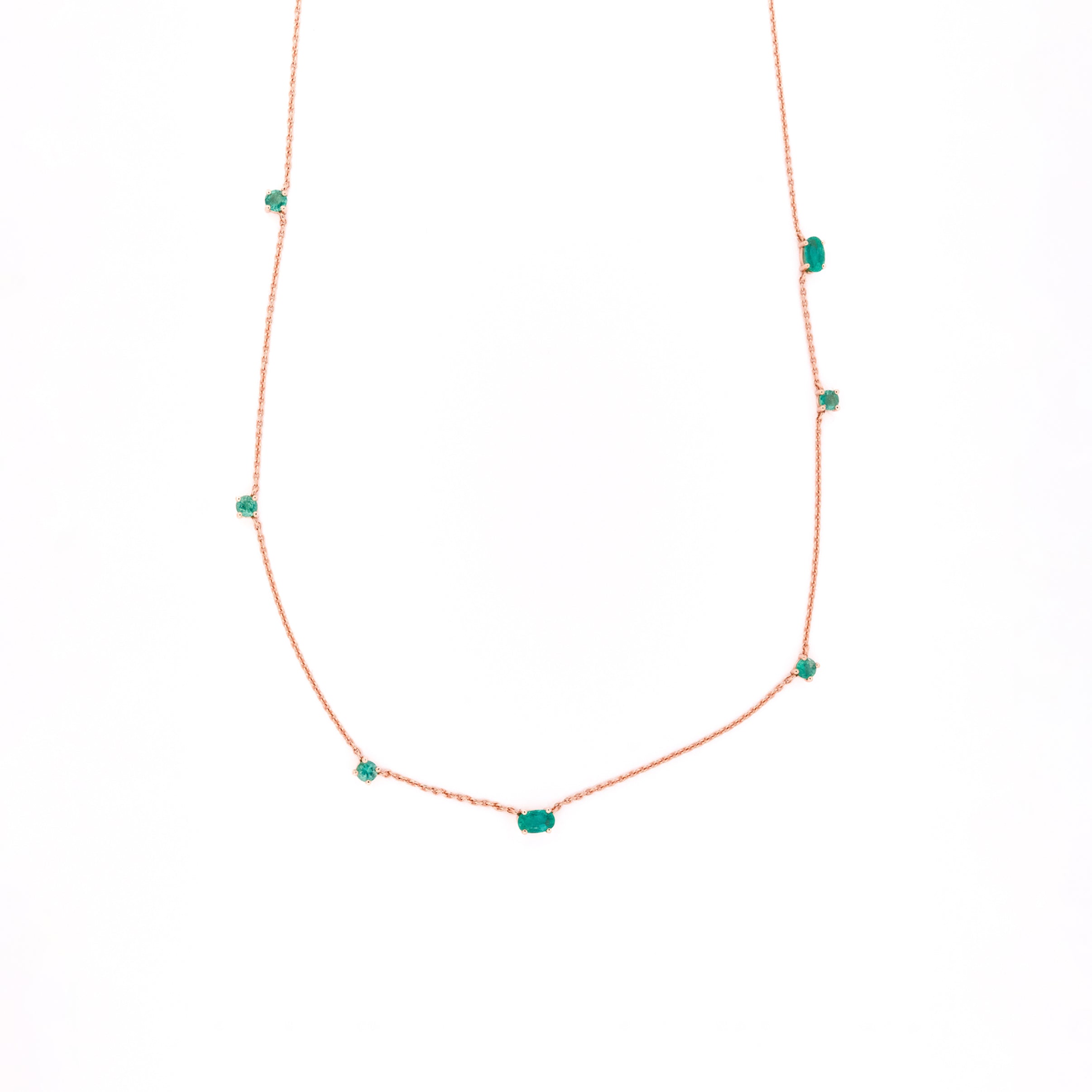 Necklace with emeralds gemstones on a white background