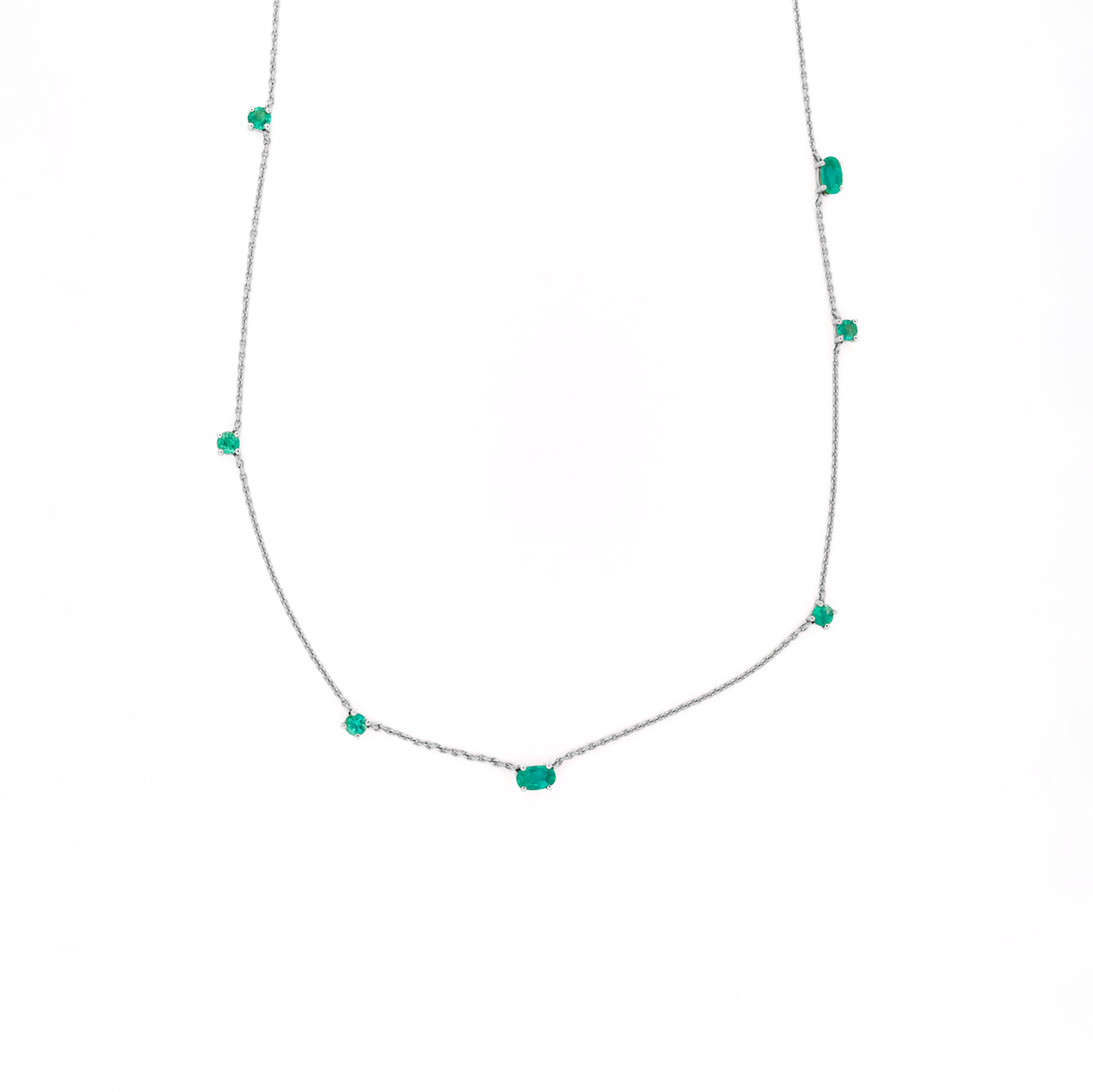 Necklace with emeralds gemstones on a white background
