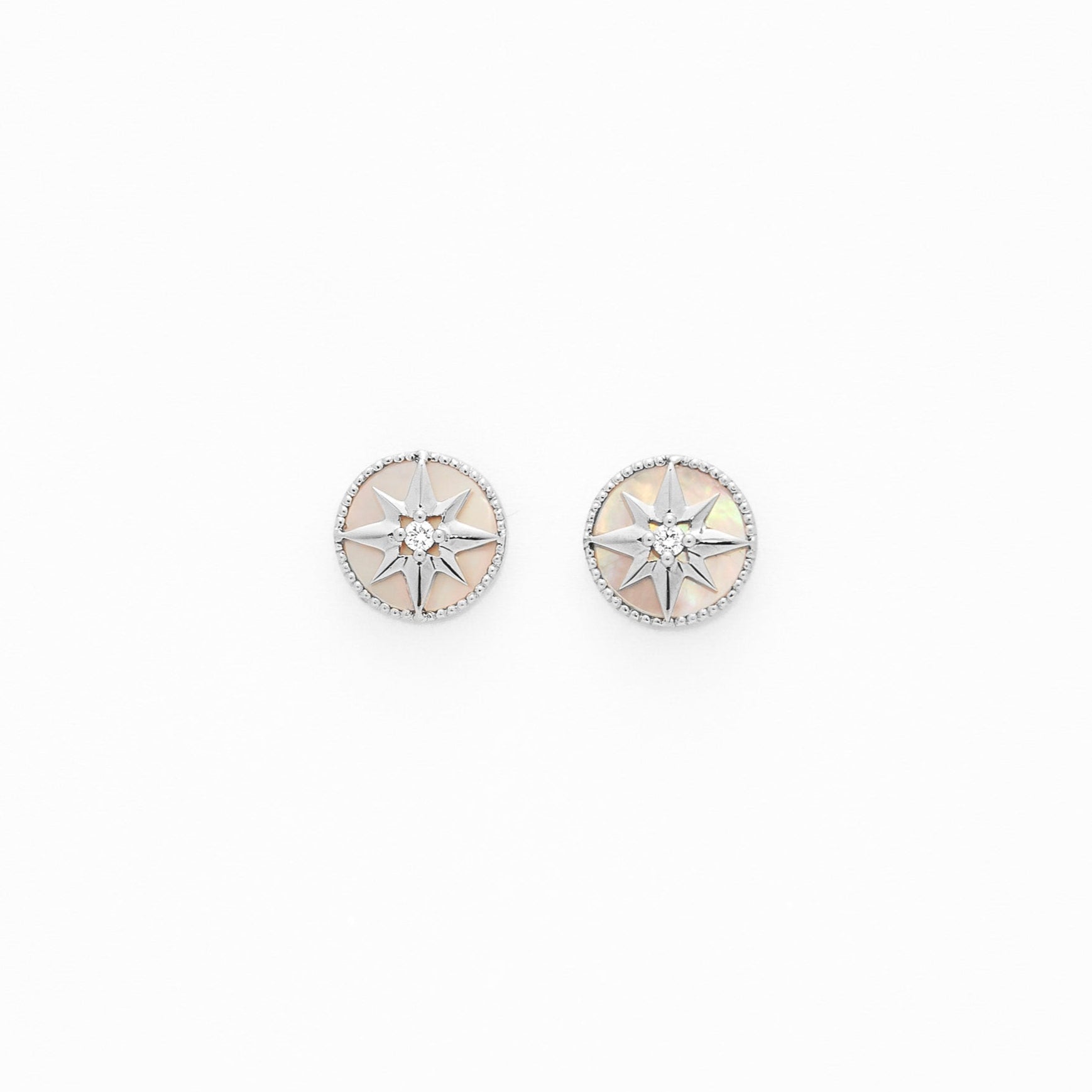 Gold studs made of mother of pearl, a north star center and a white diamonds in the middle. These are one of the most elegant pair of studs you'll own.