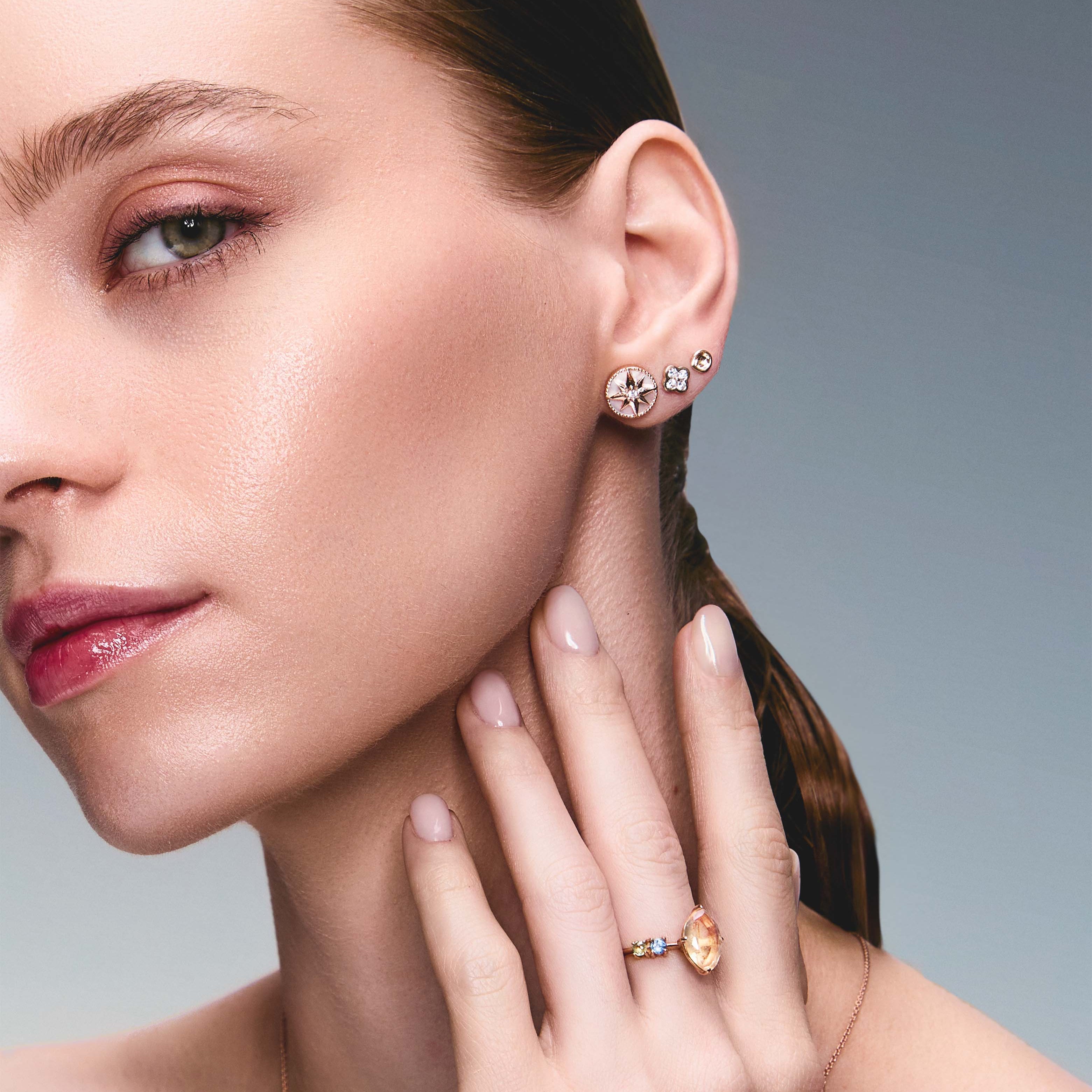 Beautiful model wearing some incredible stud earrings, one is symbolising the north star, the second earring is a diamond clover and the third earring in a simple gold scoop earring. The girl is also wearing a beautiful marquise mexican opal ring.