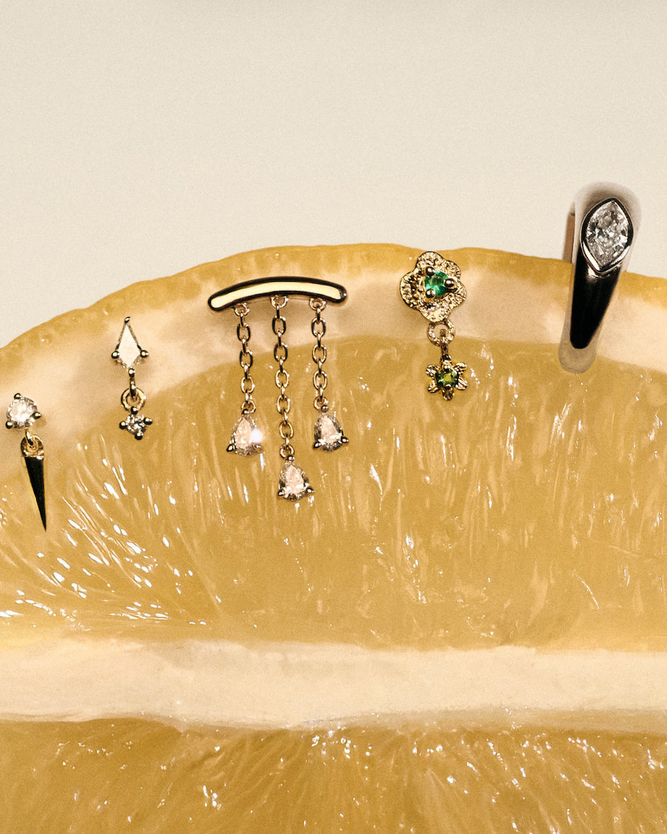 Gold earrings, Teardrop Diamonds Chandelier stud, The Floating Kite Diamond Stud, The Floating Gold Icicle Stud, The Marquise Earcuff, on a lemon with a neutral backgrounda.