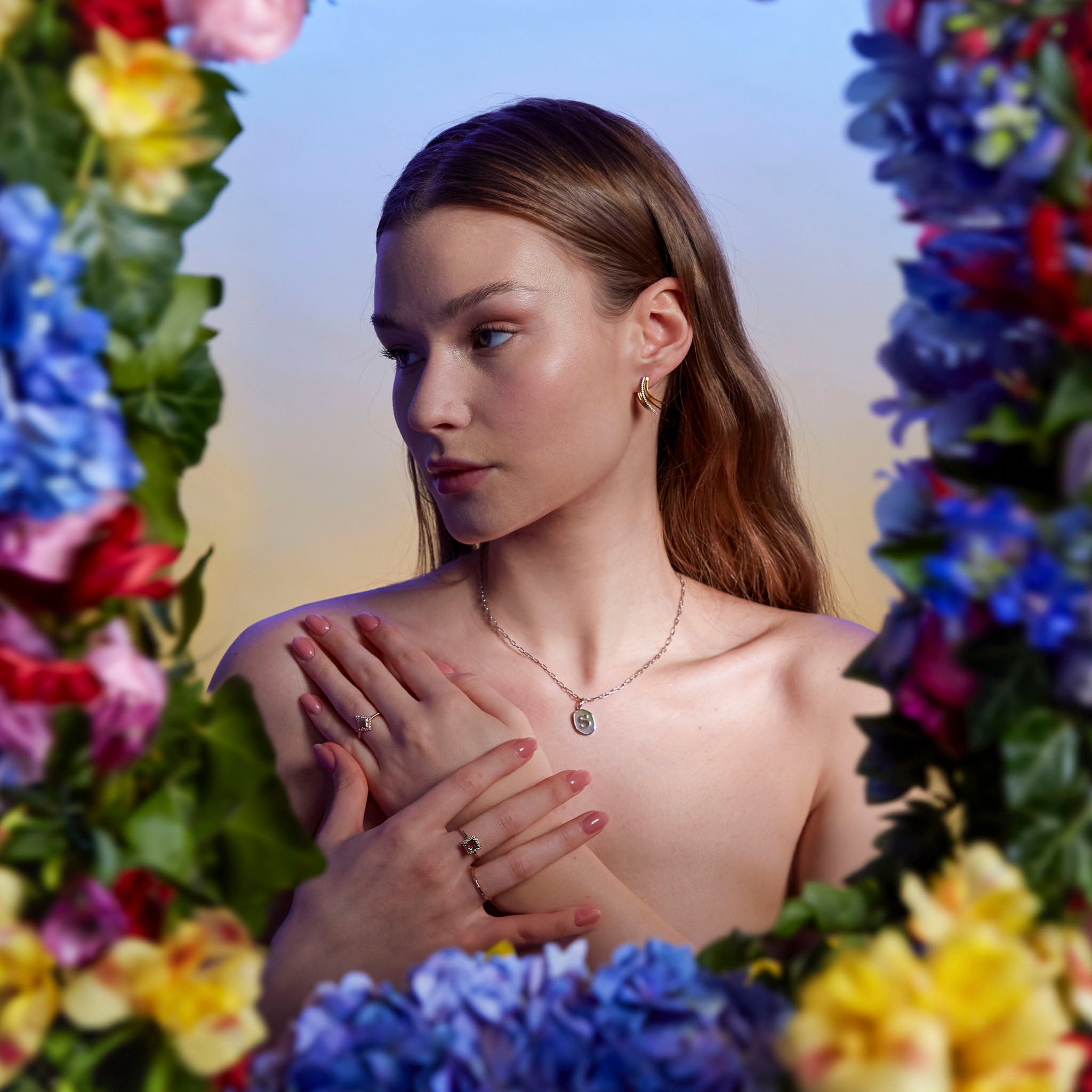 Mother of Pearl pendant, Princess tourmaline rind and salt and pepper ring on model surrounded by magical flowers. Pandant initiala din aur pe perla, inel Princess cu turmalina si inel cu diamant salt and pepper pe model, inconjutata de flori de toate culorile.