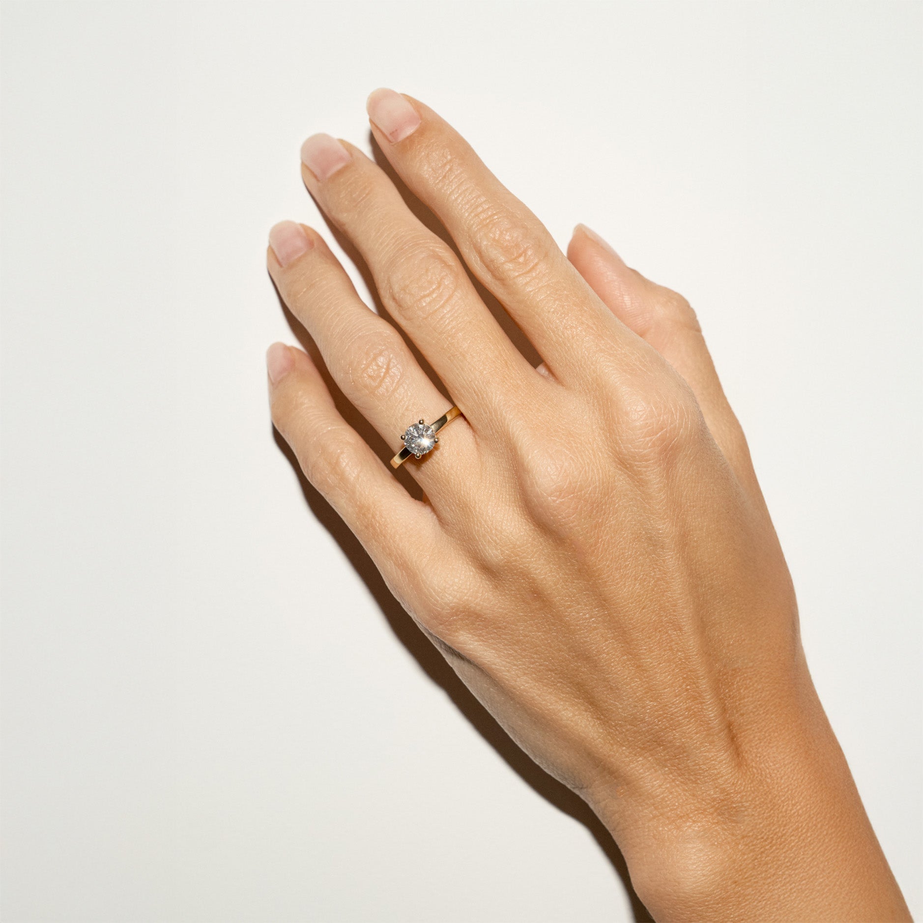 Solitaire gold ring with natural 1 ct diamond on hand