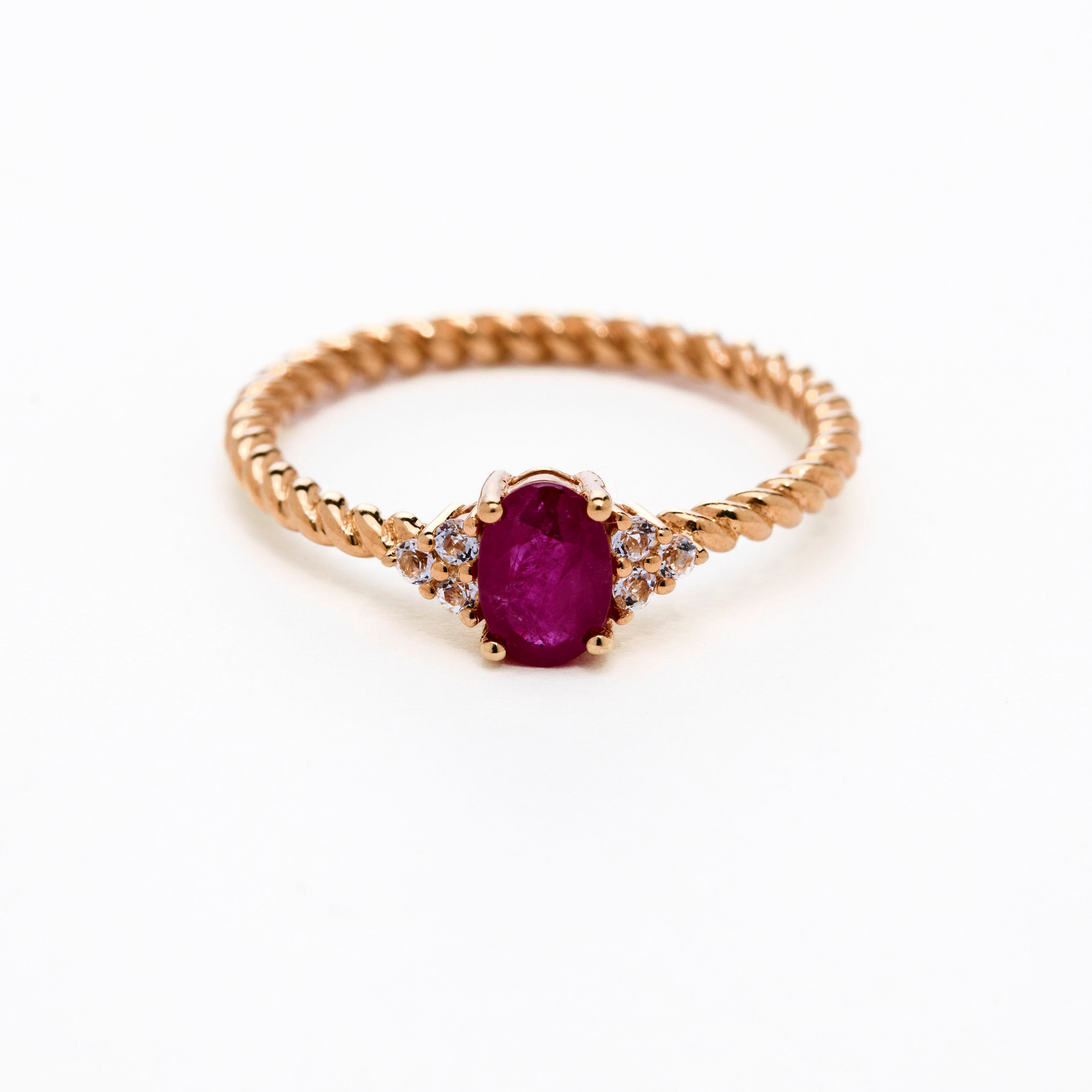 Romantic oval ruby ring with twisted band and cluster diamonds details