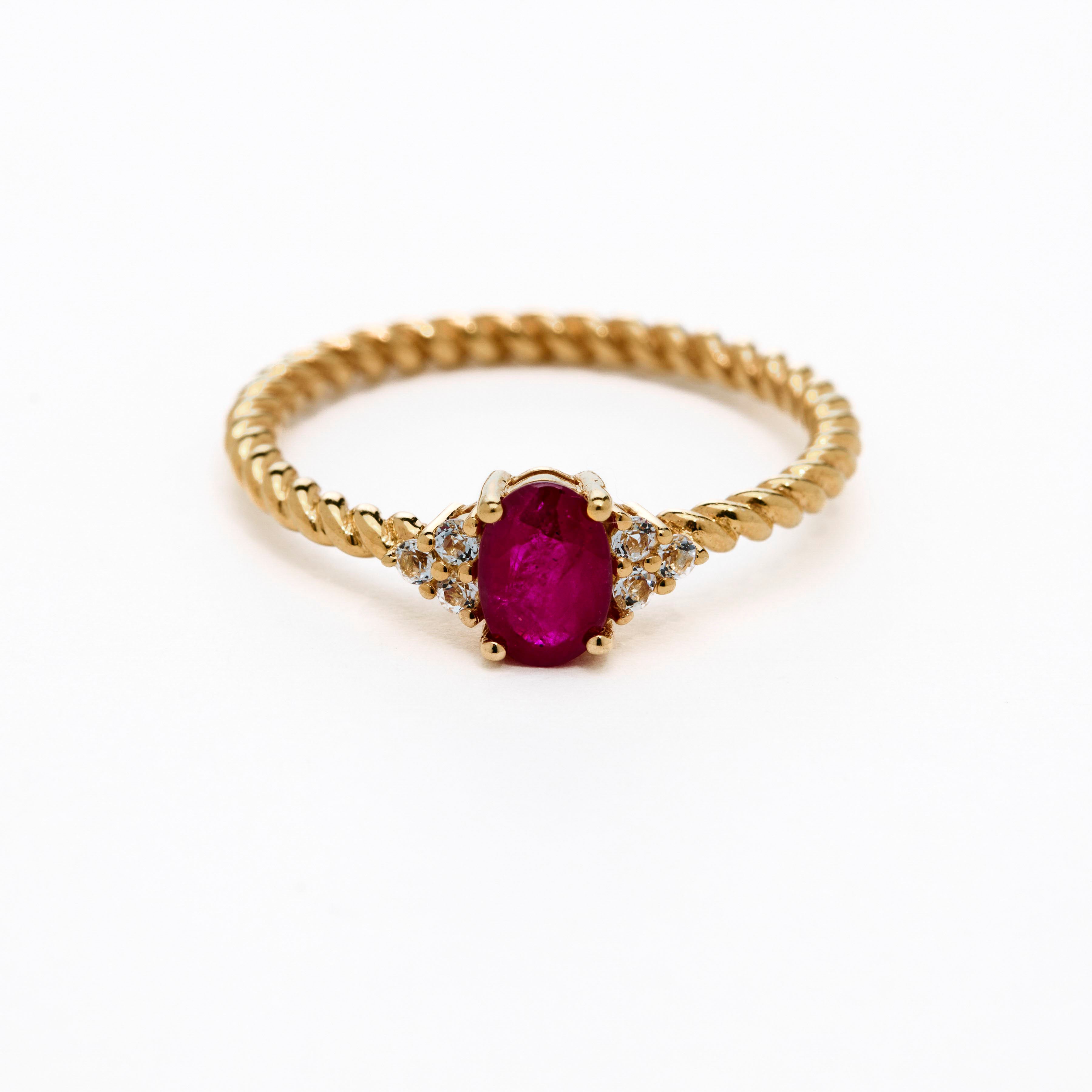 Romantic oval ruby ring with twisted band and cluster diamonds details
