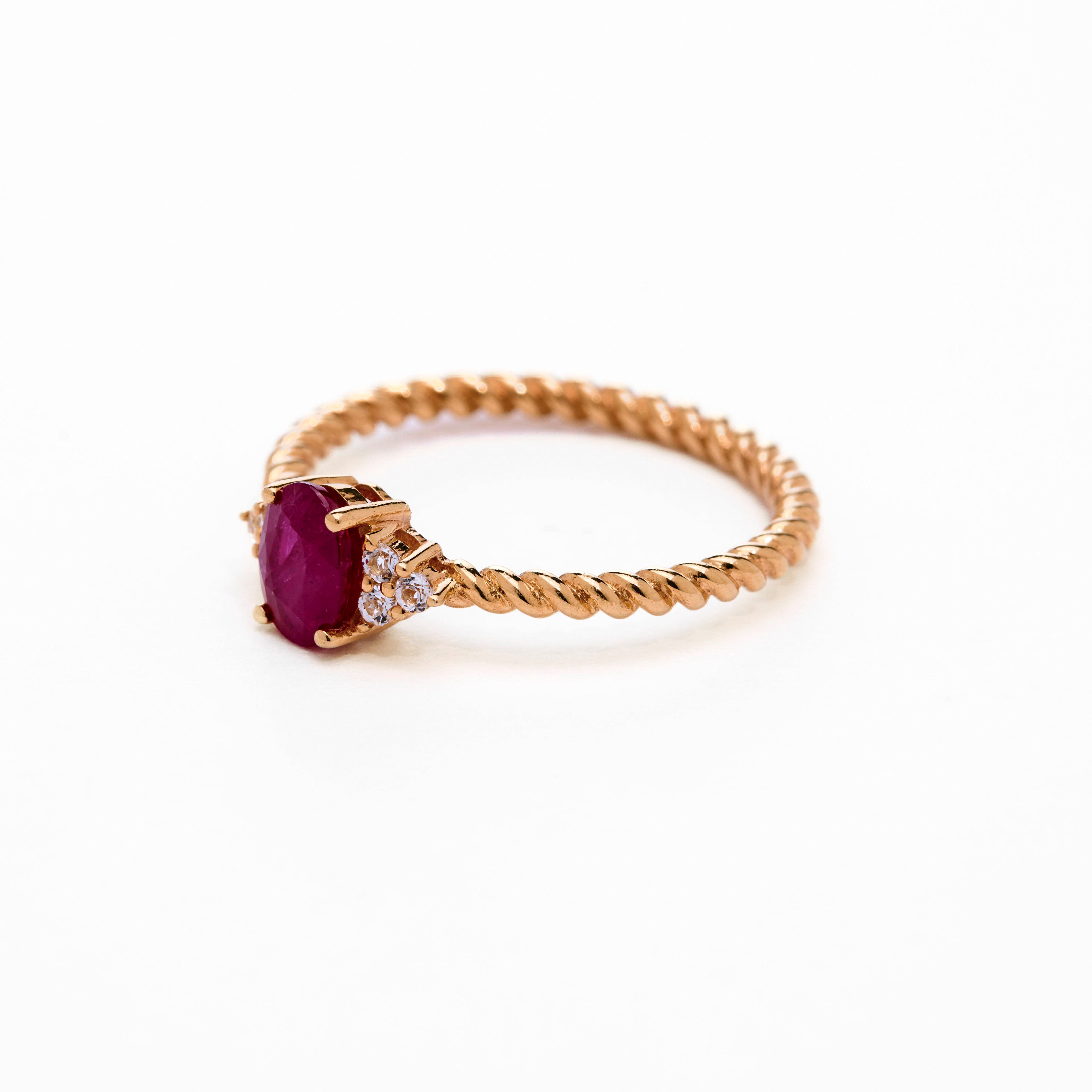 Romantic oval ruby ring with twisted band and cluster diamonds details
