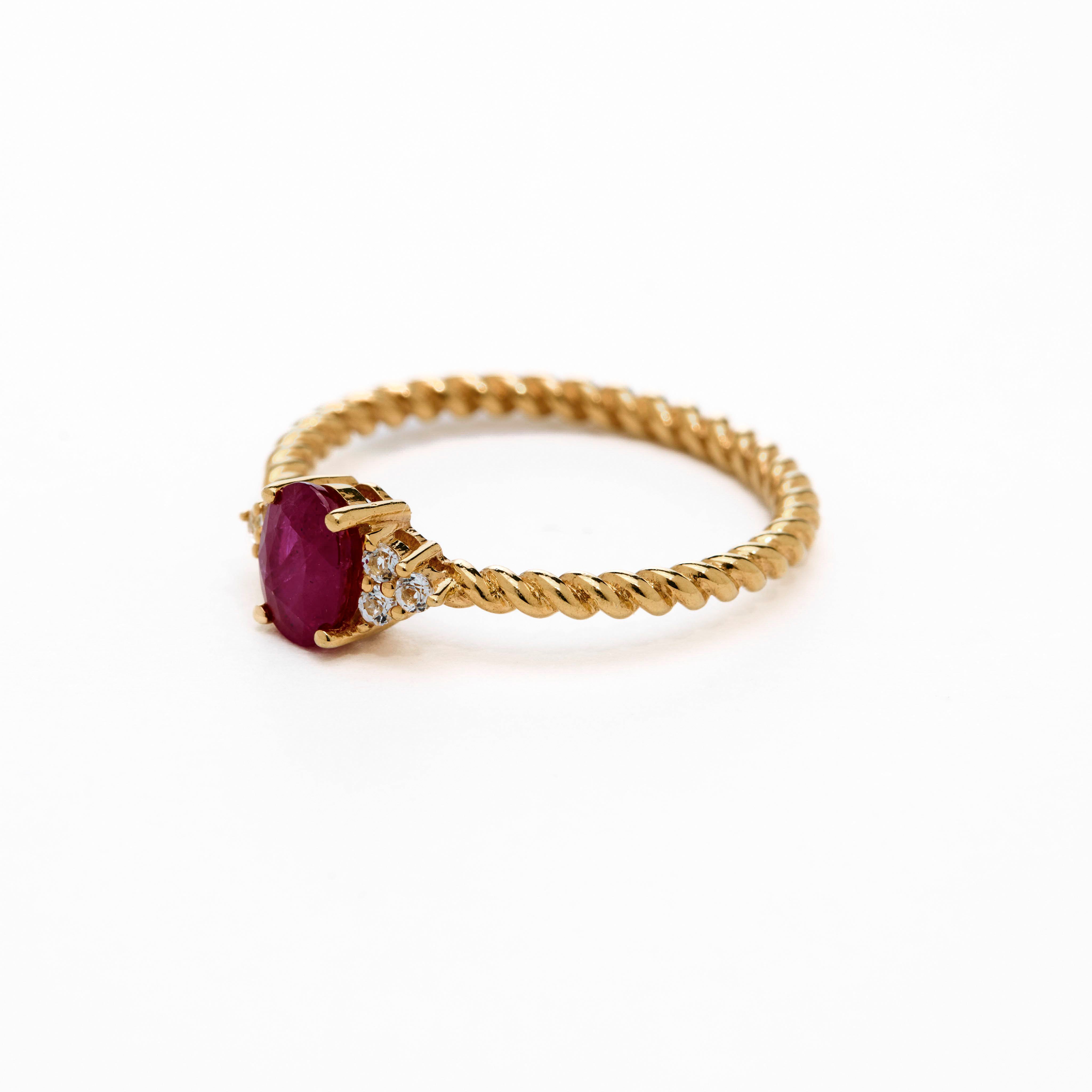 Romantic oval ruby ring with twisted band and cluster diamonds details