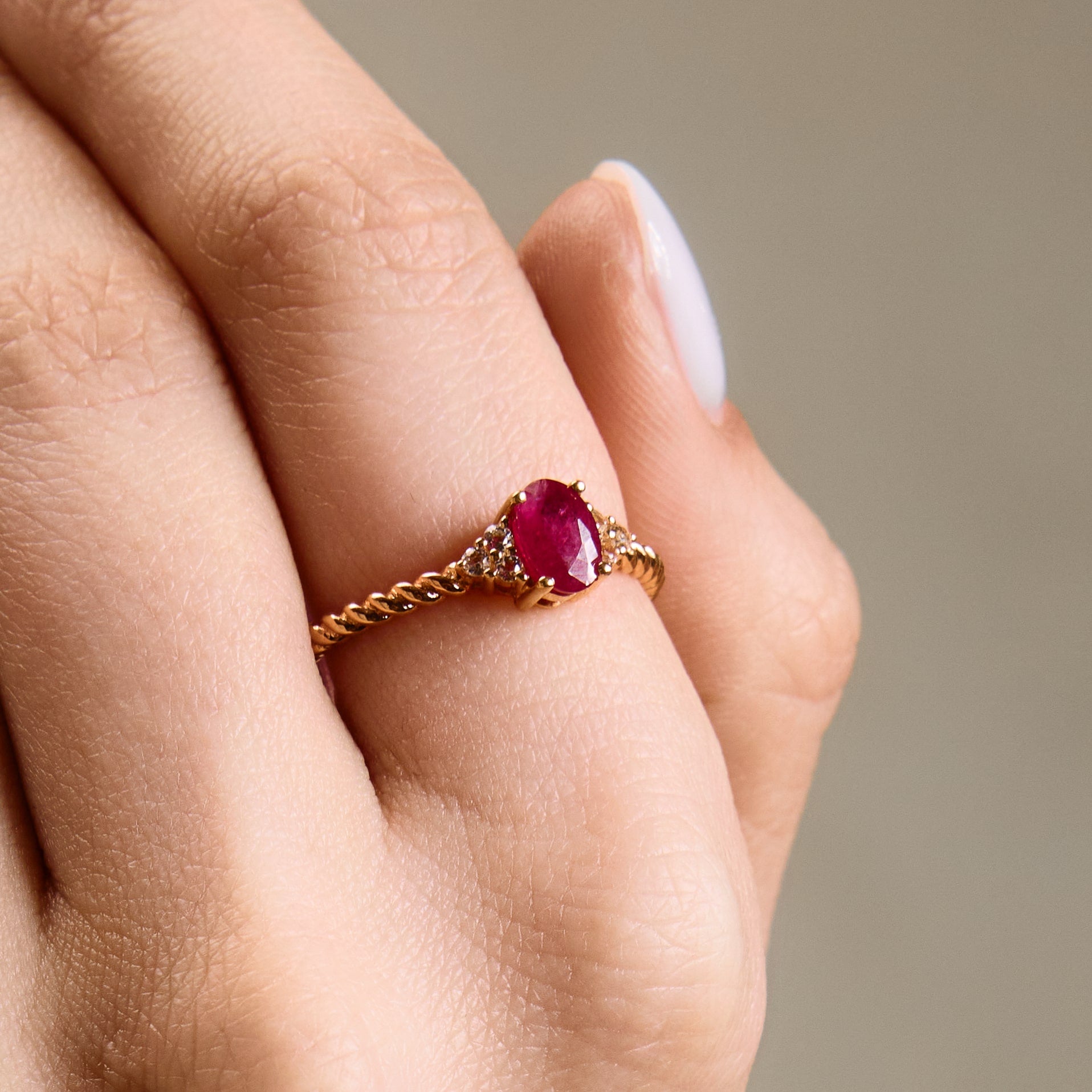 Romantic oval ruby ring with twisted band and cluster diamonds details