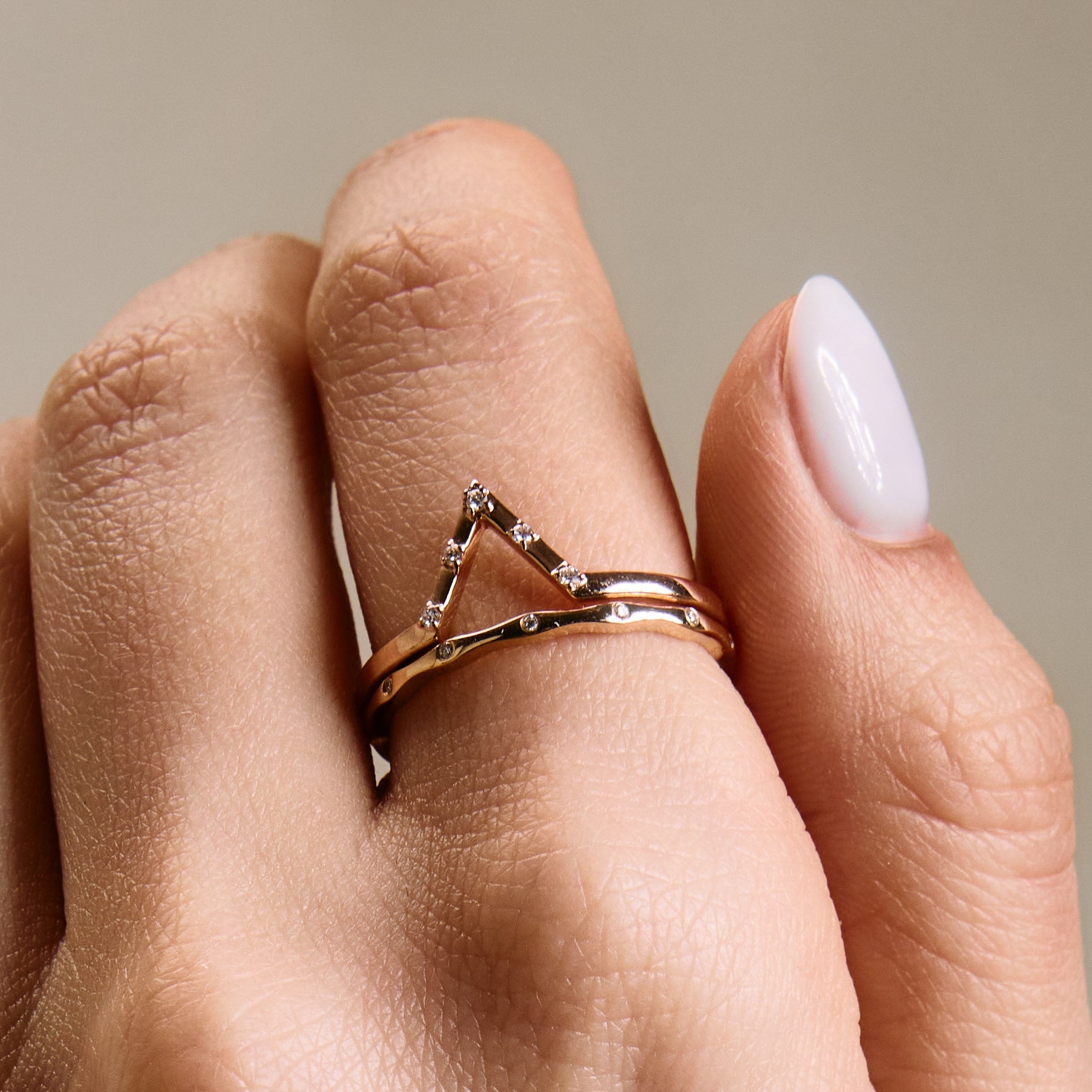 the rose gold Penta wedding band mixed with wave wedding band on hand, close up