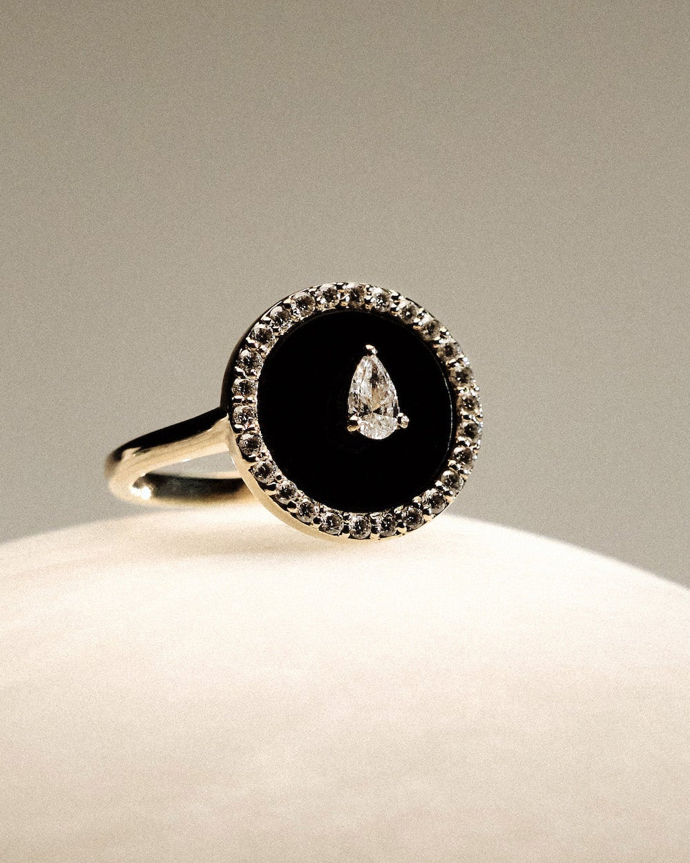 Black Onyx and diamonds Gold Ring on a round marble.