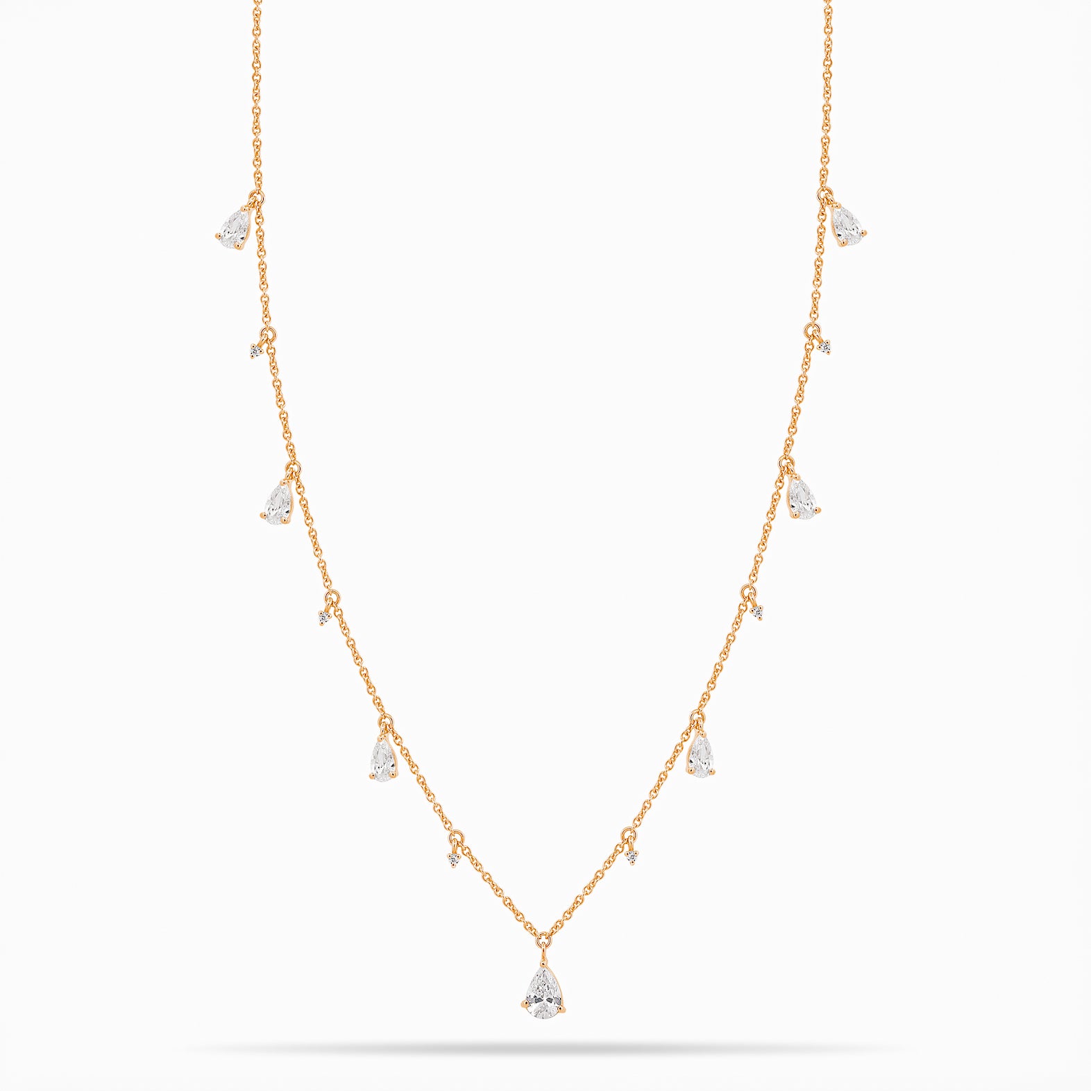 Rose Gold necklace with teardrop and round diamond pendants on a white background