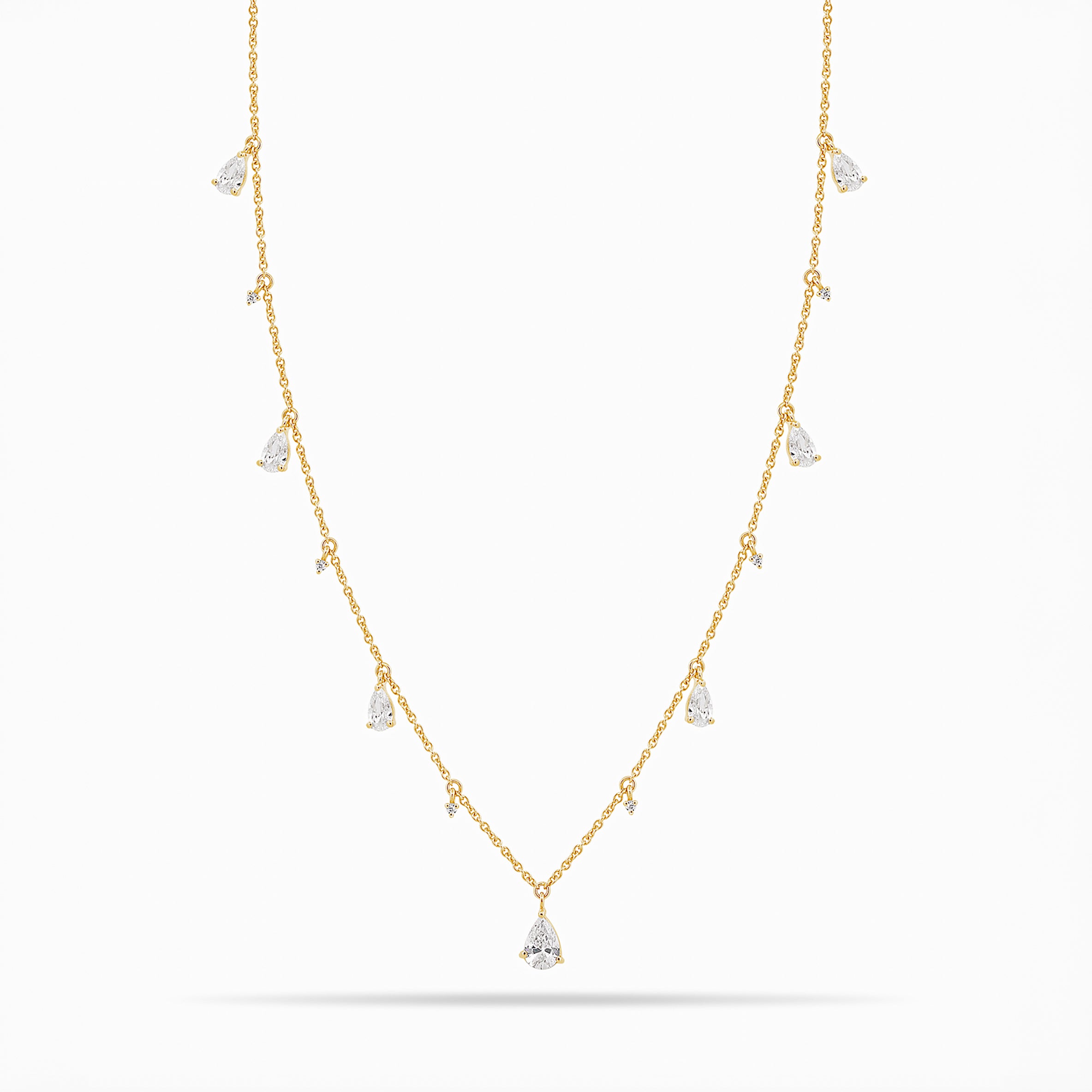Yellow Gold necklace with teardrop and round diamond pendants on a white background