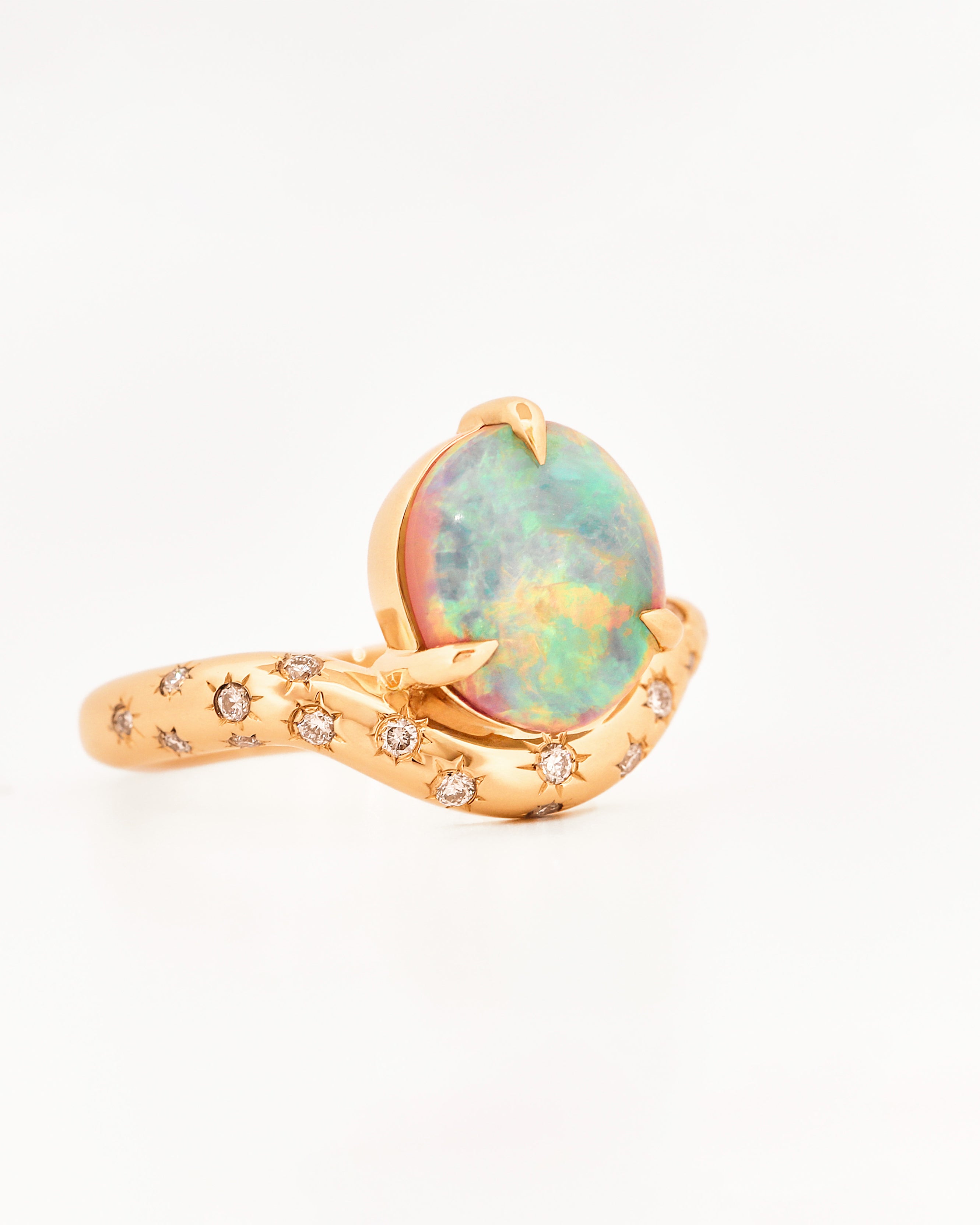 Yellow Gold ring with an australian opal centrestone on a white background.