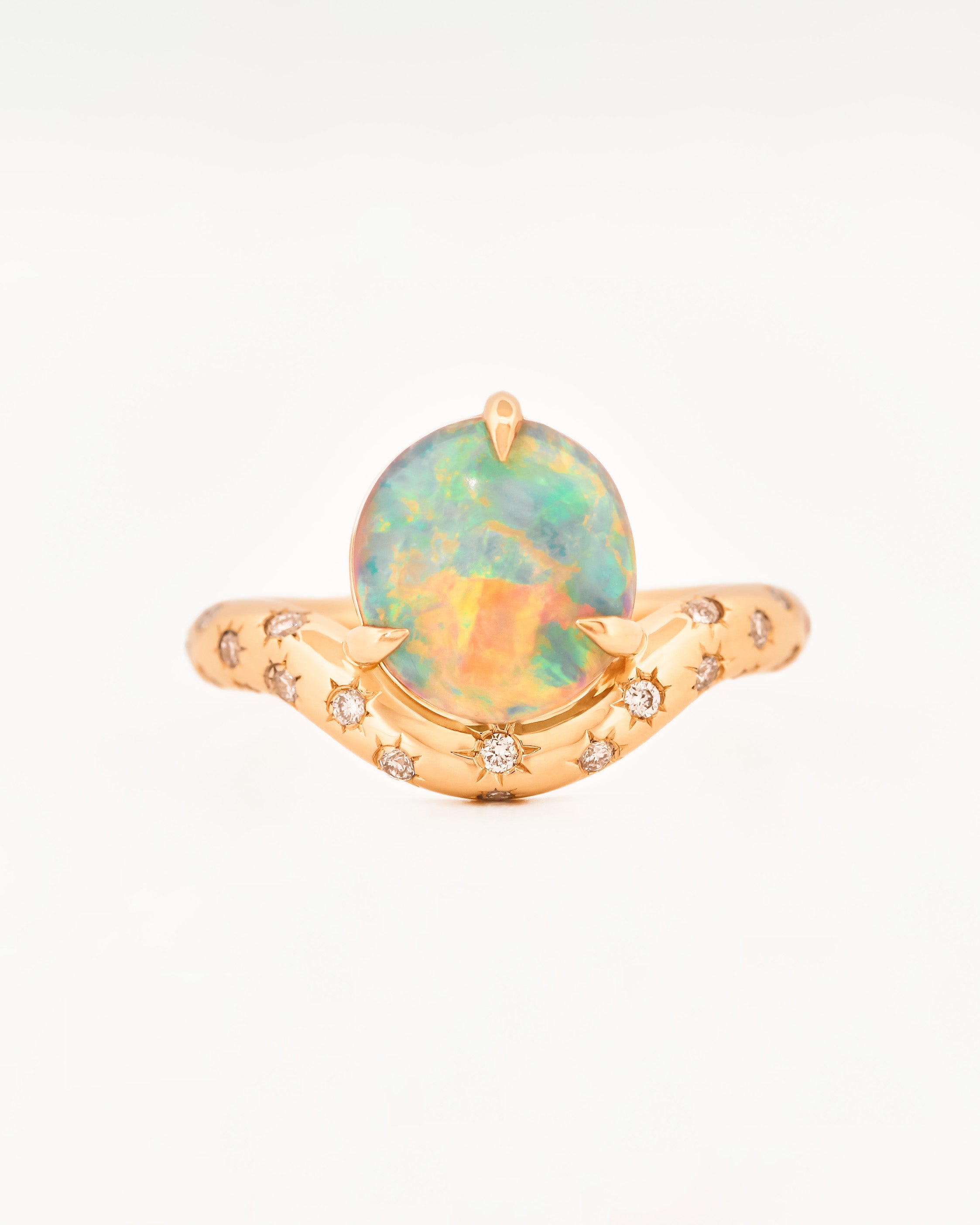 Yellow Gold ring with an australian opal centrestone on a white background.