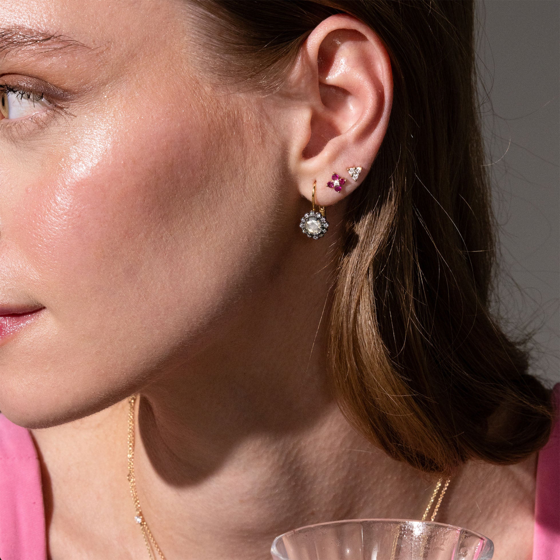 beautiful rose cut diamonds earrings, set in black rhodium 14k or 18k gold, and a dainty trilogy diamonds stud earring on models ear