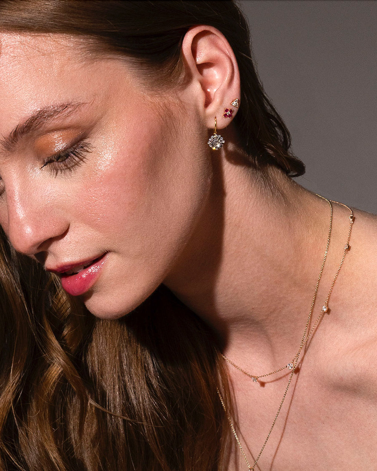 beautiful rose cut diamonds earrings, set in black rhodium 14k or 18k gold, and a dainty trilogy diamonds stud earring on models ear