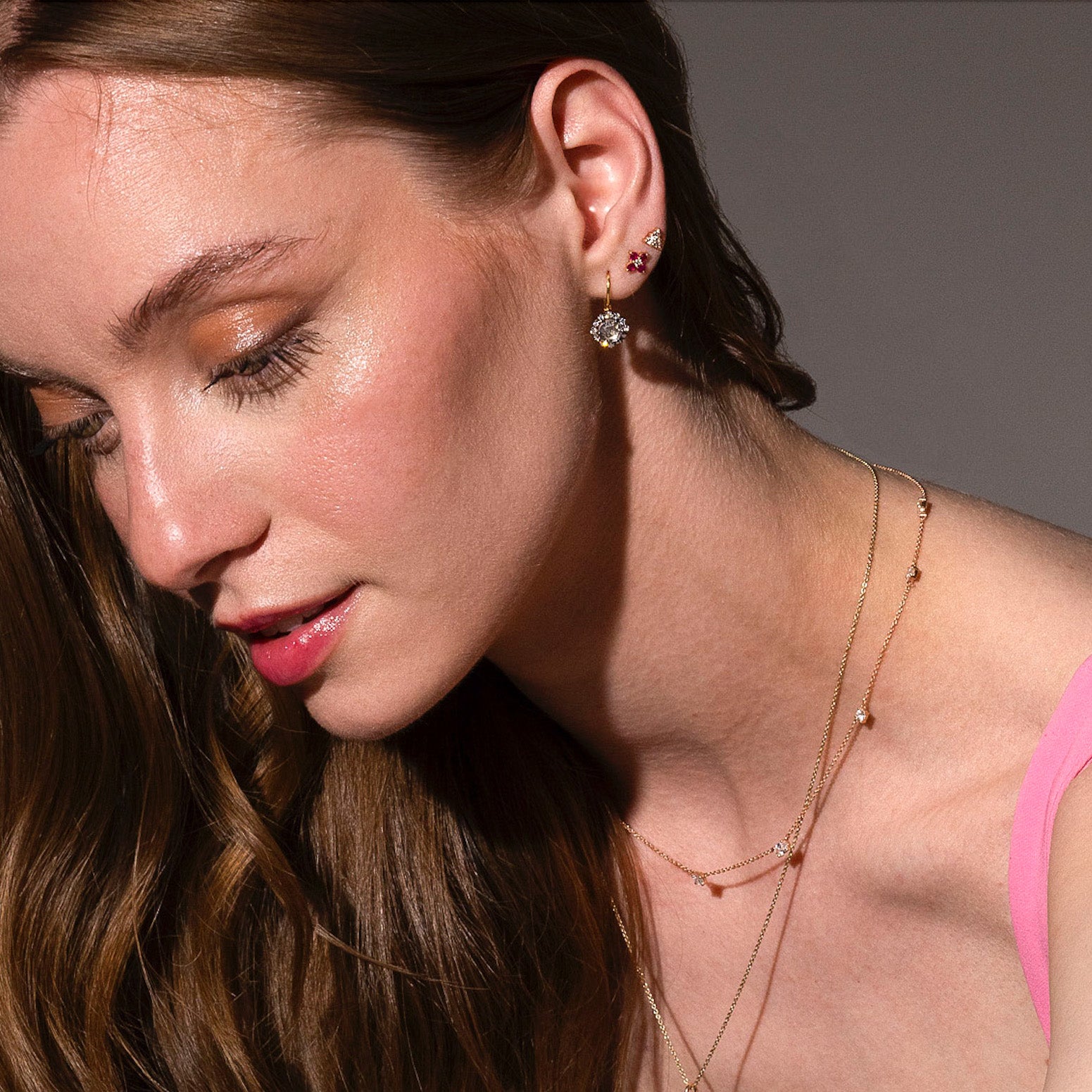 beautiful rose cut diamonds earrings, set in black rhodium 14k or 18k gold, and a dainty trilogy diamonds stud earring on models ear