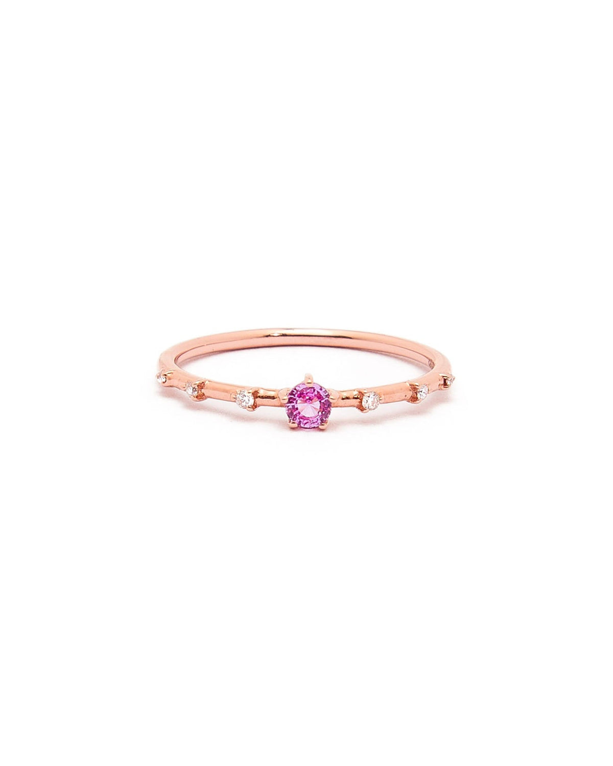 A gold band ring featuring a central sapphire with smaller diamond accents around it, presented against a white background.