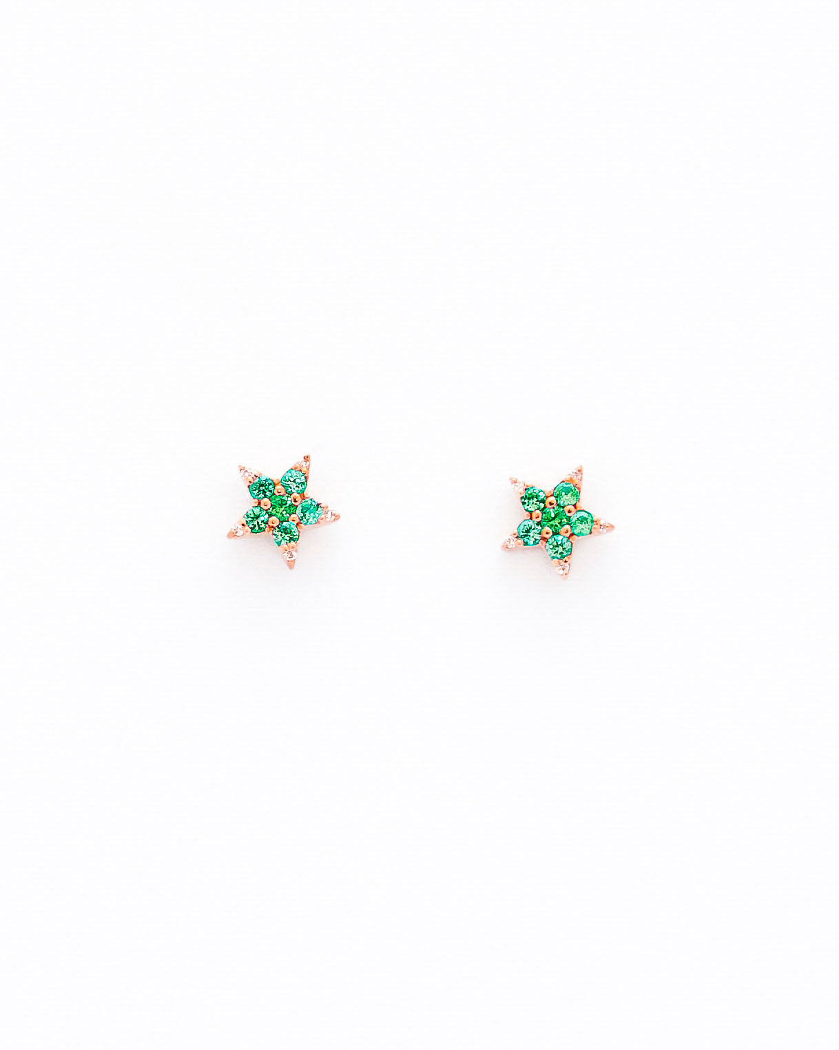 A pair of star-shaped stud earrings crafted from 14k gold, featuring round emeralds and diamonds.