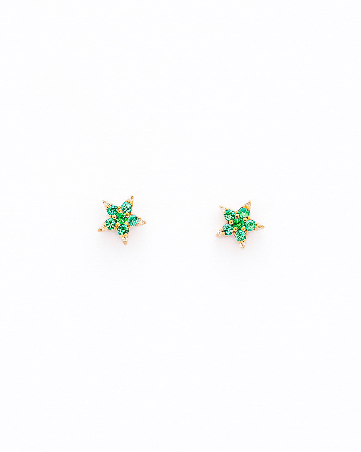 A pair of star-shaped stud earrings crafted from 14k gold, featuring round emeralds and diamonds.