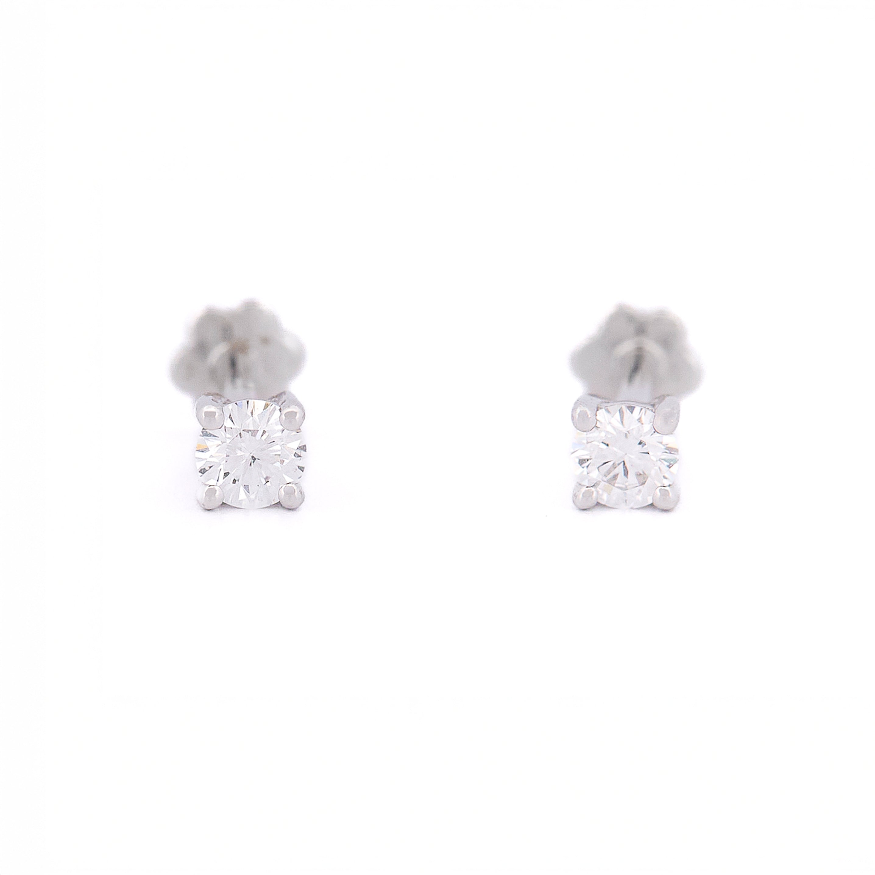 Pair of diamond stud earrings on a white background