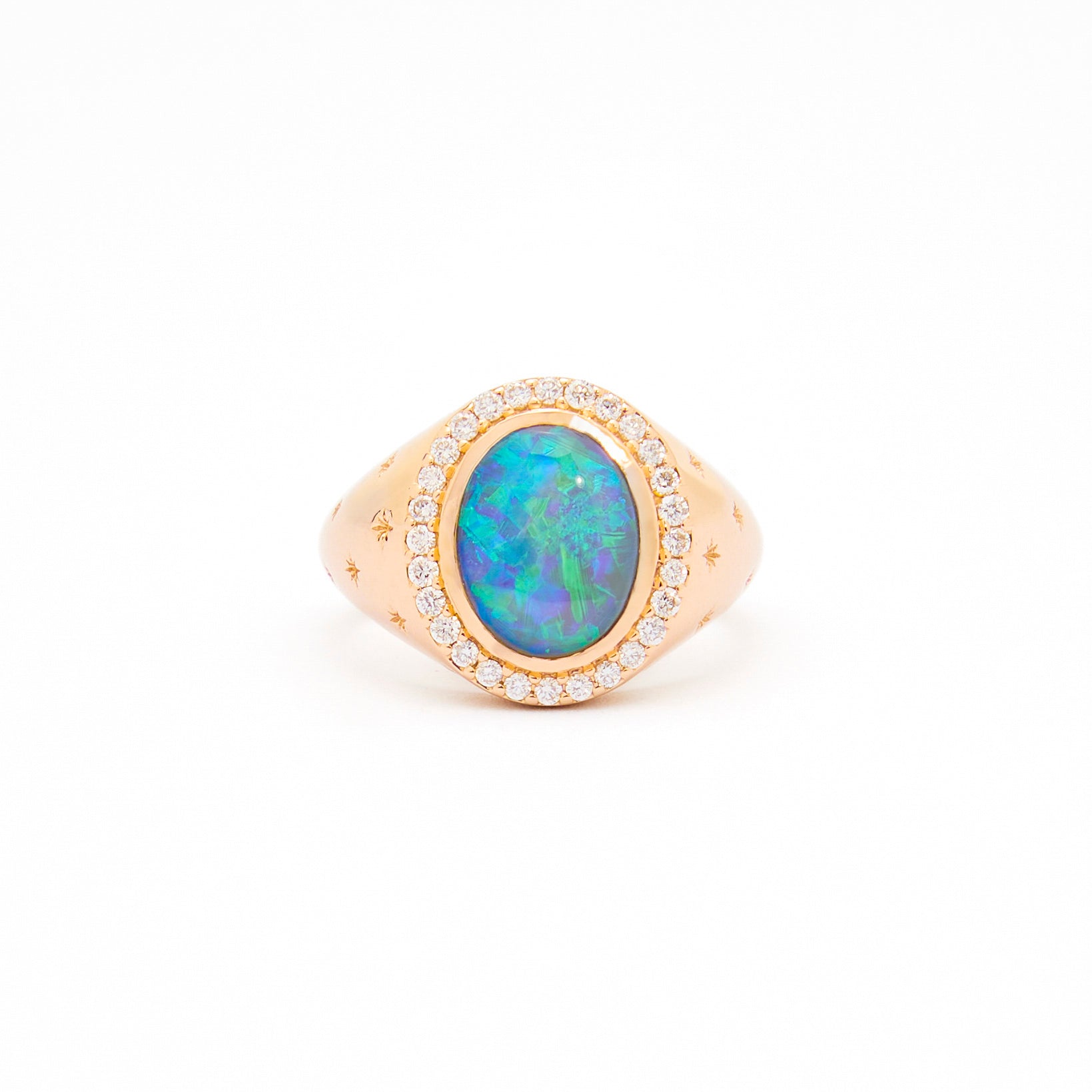 An Australian Opal and Diamonds Signet Ring in yellow gold with the opal as the centrepiece, surrounded by white diamonds and set on a white background.