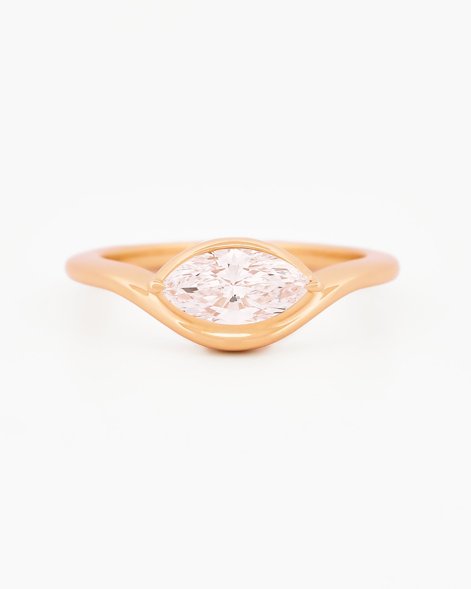 Yellow gold solitaire ring with a marquise diamond on a white background.