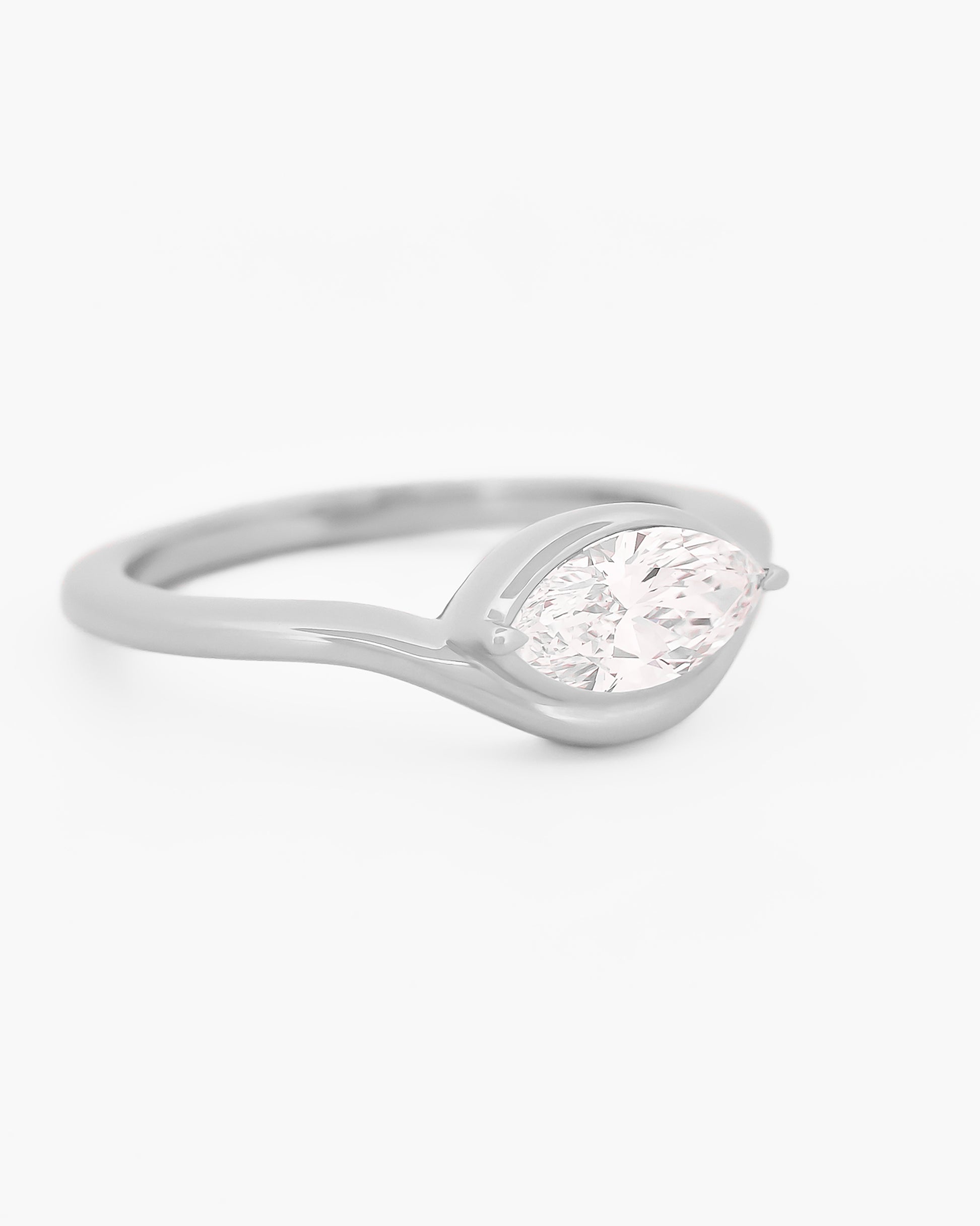 white gold solitaire ring with a marquise diamond on a white background